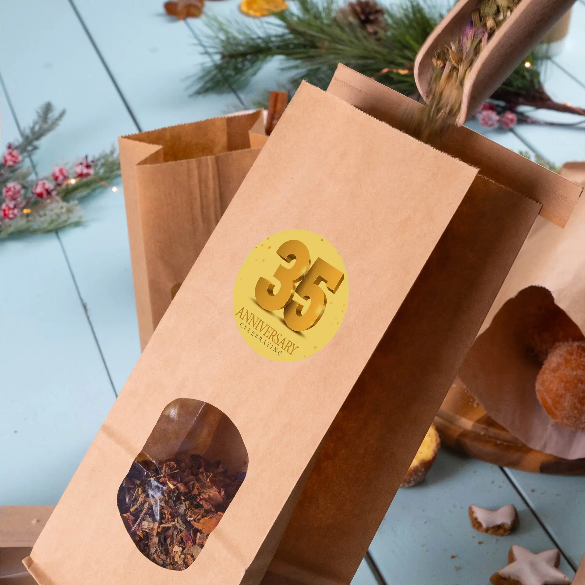Bruine kraftpapieren tas met een doorzichtig venster dat gedroogde kruiden en een gouden ronde label met "35 JAAR VIERING" toont.