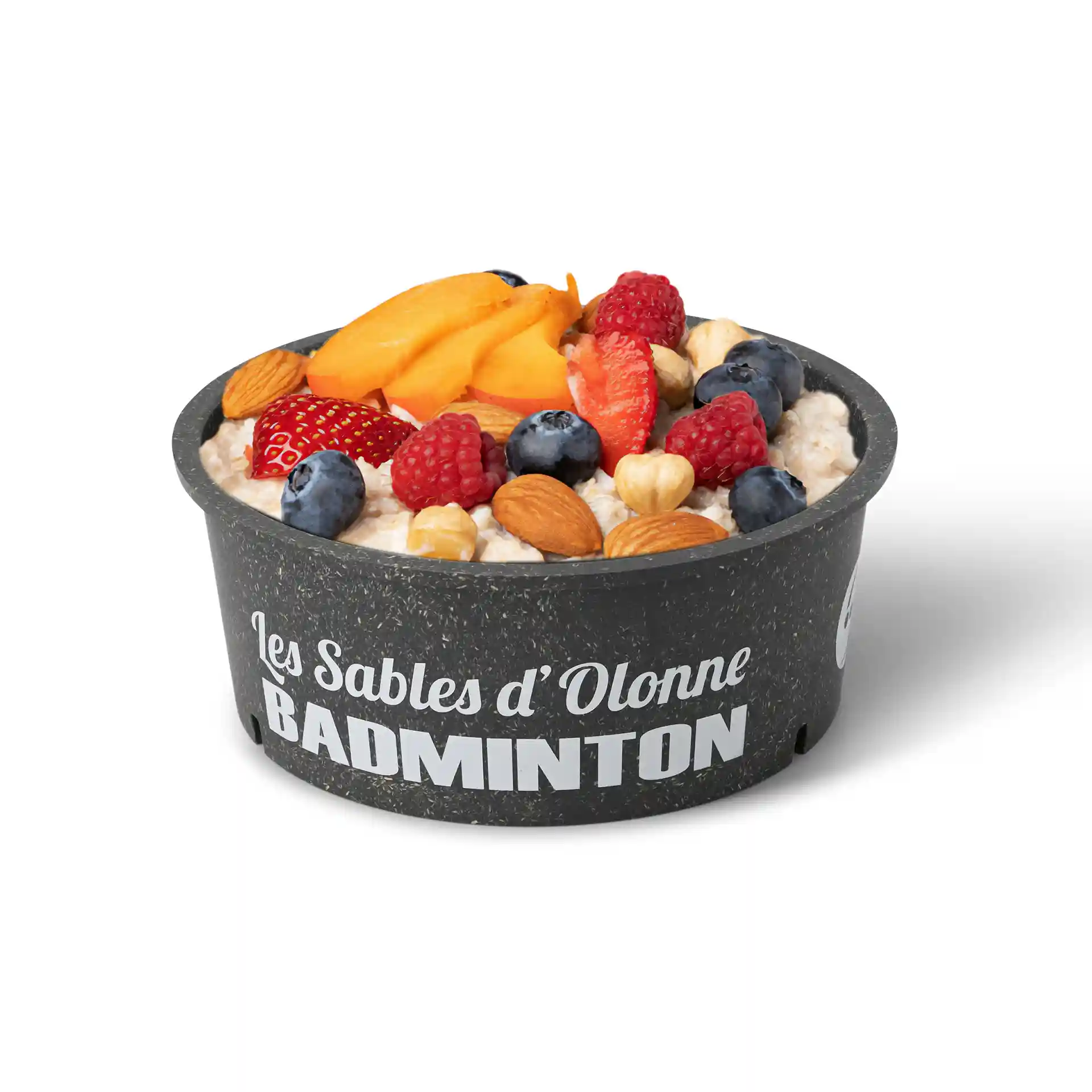 Ronde grijze herbruikbare kom gevuld met havermout, getopt met fruit en noten, op een witte achtergrond.