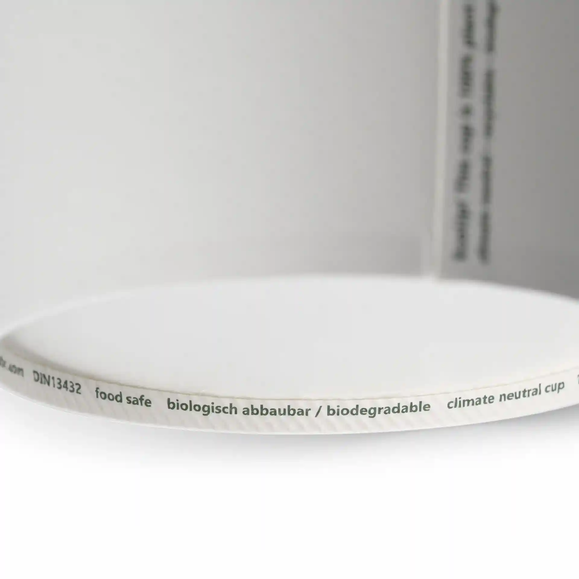 Close-up van de rand van een witte kartonnen soepcontainer met een label en een gladde binnenkant.