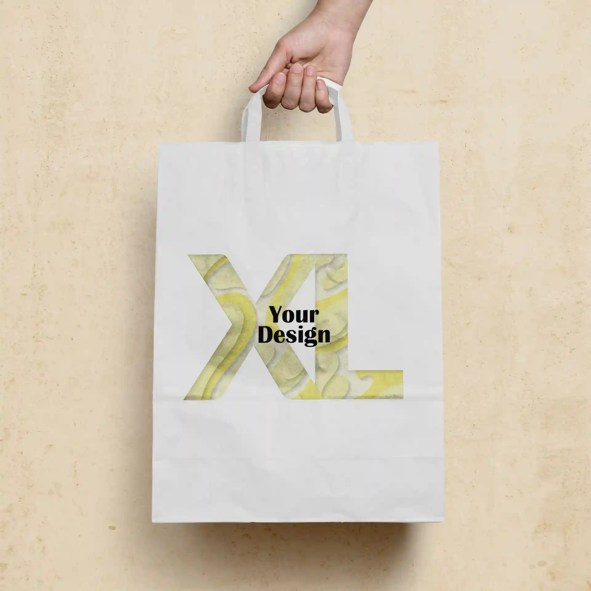 Witte papieren draagtas vastgehouden door een hand, met een groot "XL"-ontwerp en de tekst "Jouw Ontwerp" aan de voorkant.