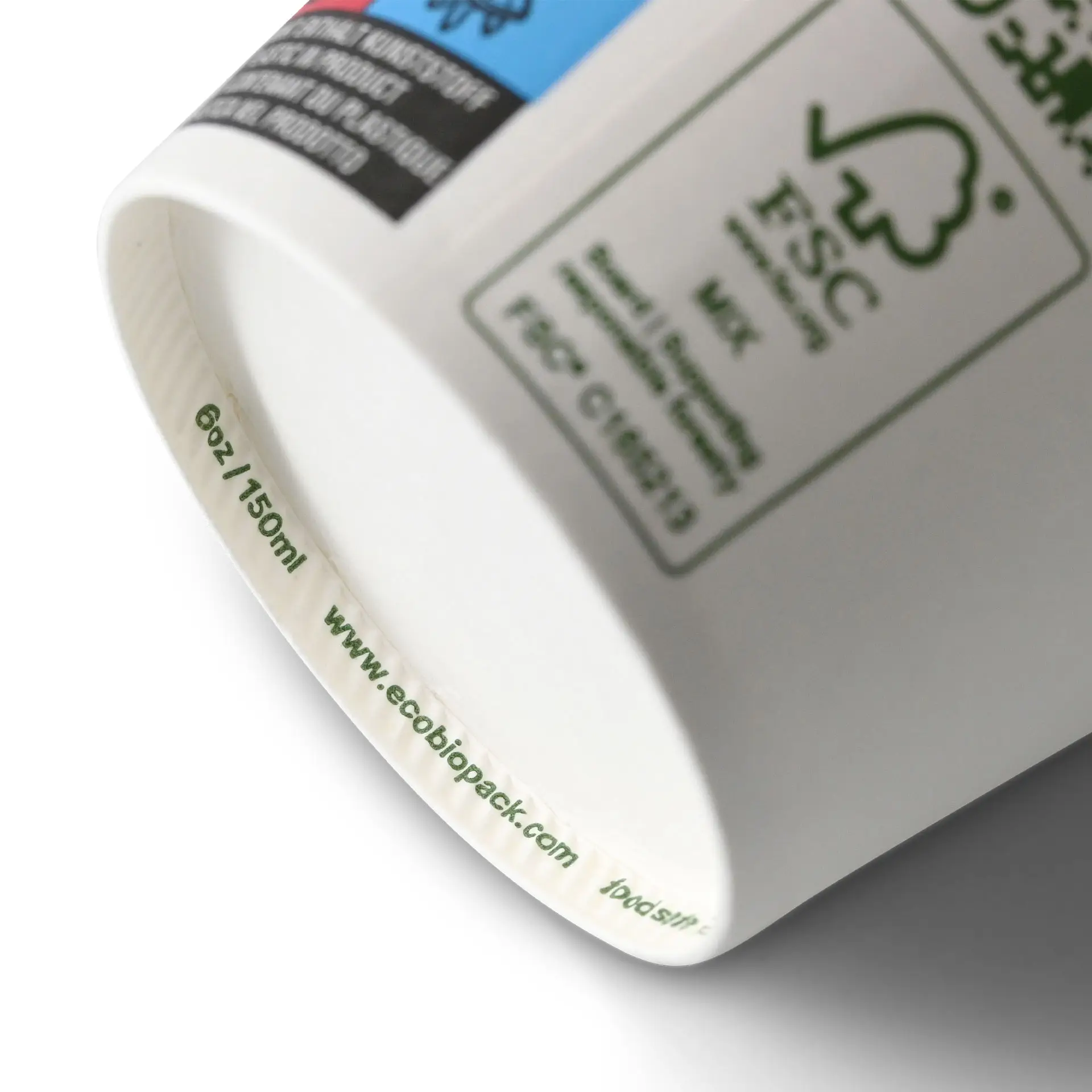 Een witte biologisch afbreekbare beker toont zijn basis met maatmarkeringen; bevat labels en certificeringsmerken.