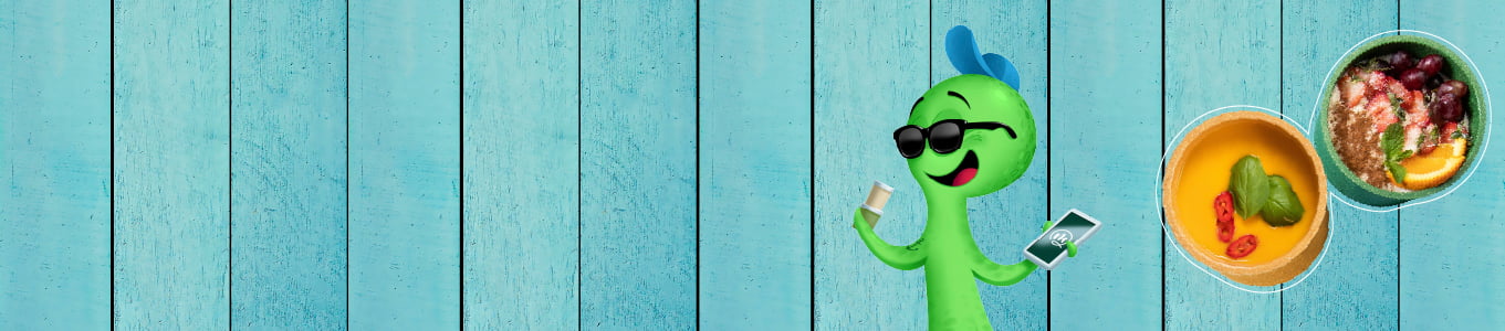 Groen cartoonfiguur met zonnebril, houdt een drankje en een telefoon vast, met komkommers op een blauwe houten achtergrond.