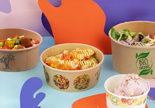 Bruine biologisch afbreekbare slaatschalen met diverse salades; één kom is open met een deksel erbij.