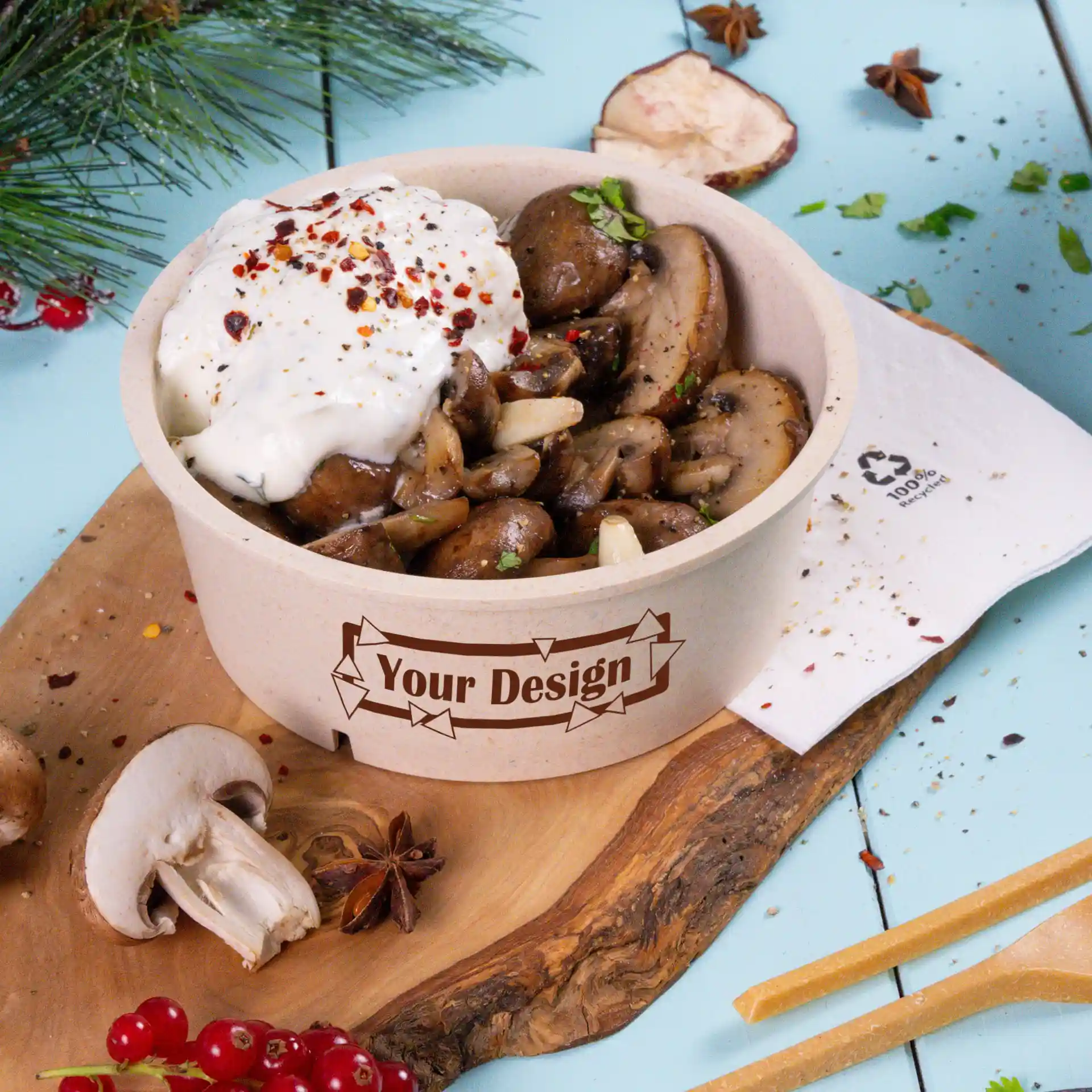 Ronde crème-witte herbruikbare kom gevuld met gebakken champignons en getopt met zure room, op een houten plank.