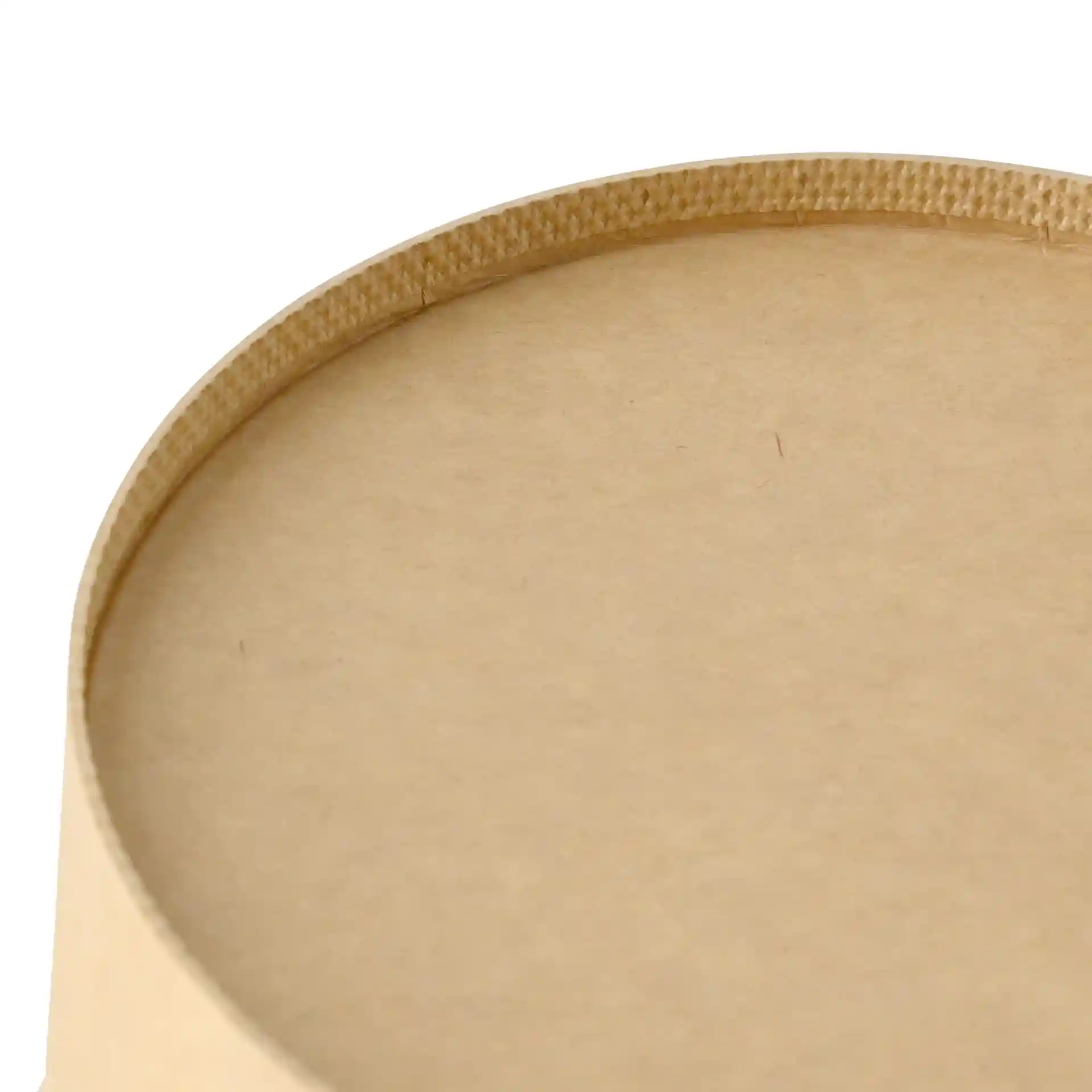 Close-up van de bovenrand van een ronde bruine kartonnen kom met een gladde oppervlakte en zichtbare naad.