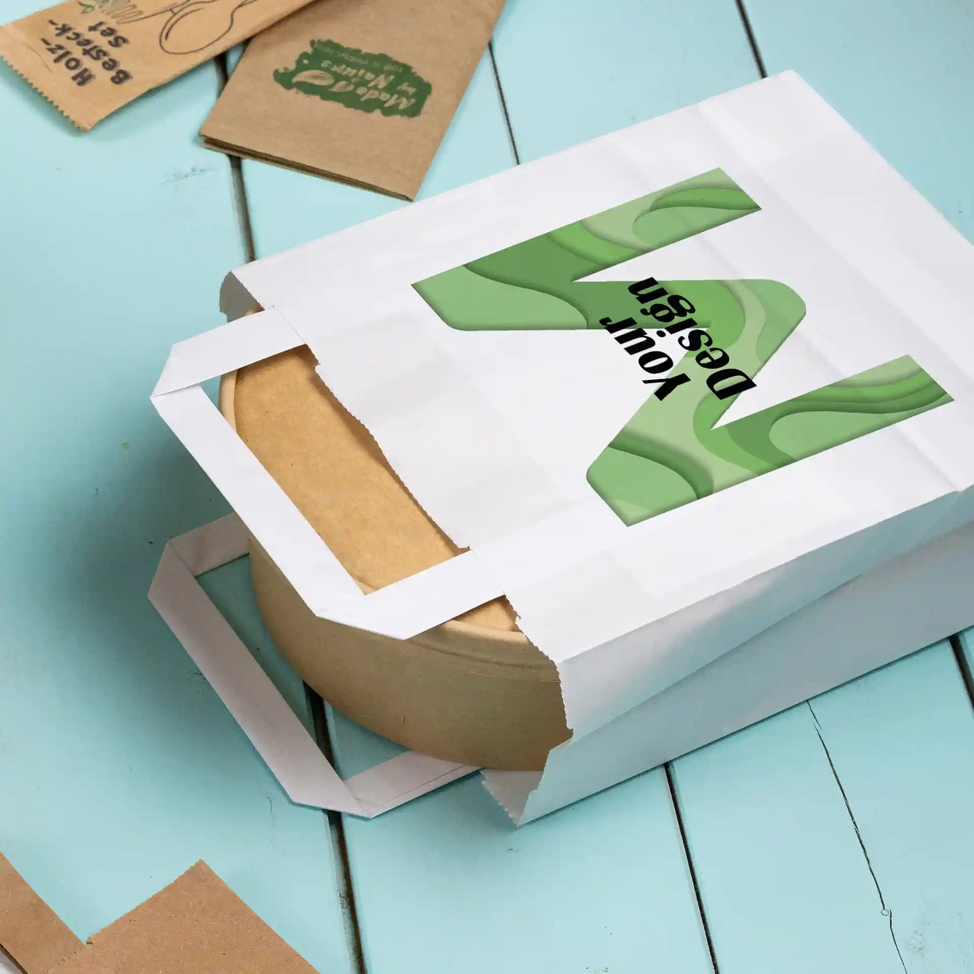 Witte papieren draagtas in rechthoekige vorm, met een bruine ronde container binnenin en een ontwerp aan de voorkant.