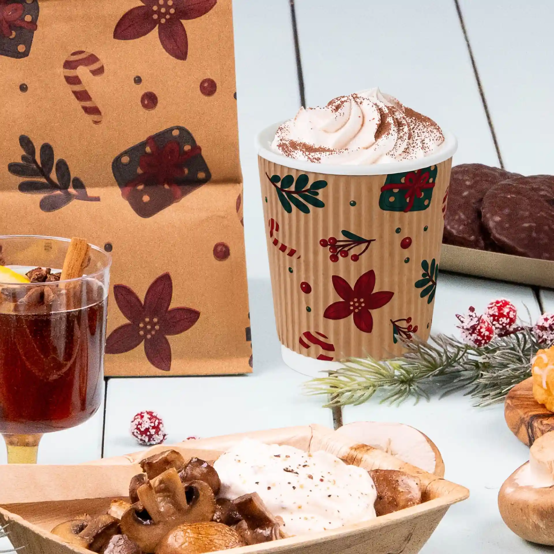 Afbeelding van een 200 ml bruine golfbeker met een winterontwerp, gevuld met slagroom, naast verschillende feestelijke snacks.