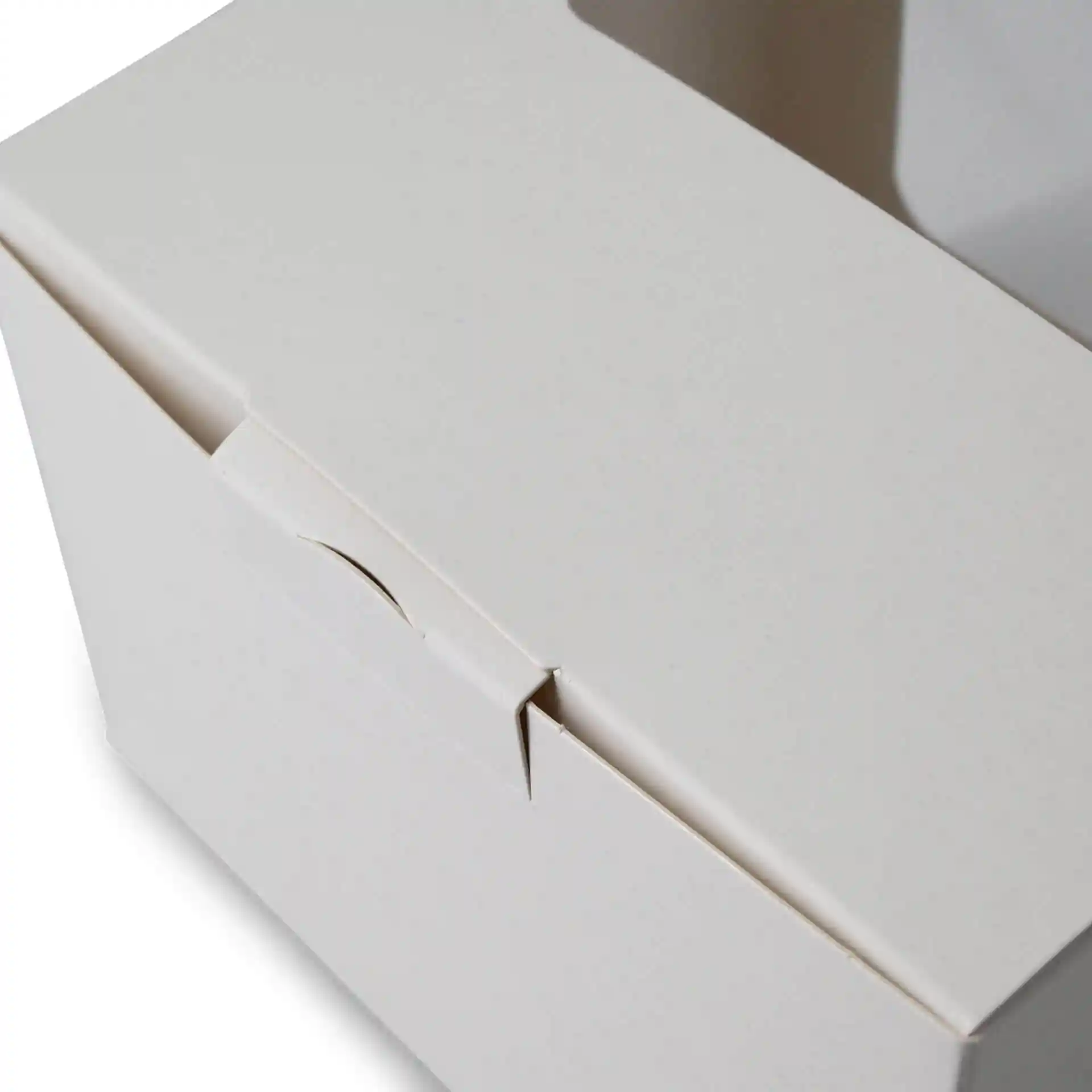 Witte gebakdoos met cellulosevenster, toont de bovenklep en een deel van de zijkant. Afmetingen: 13 x 11 x 8 cm.