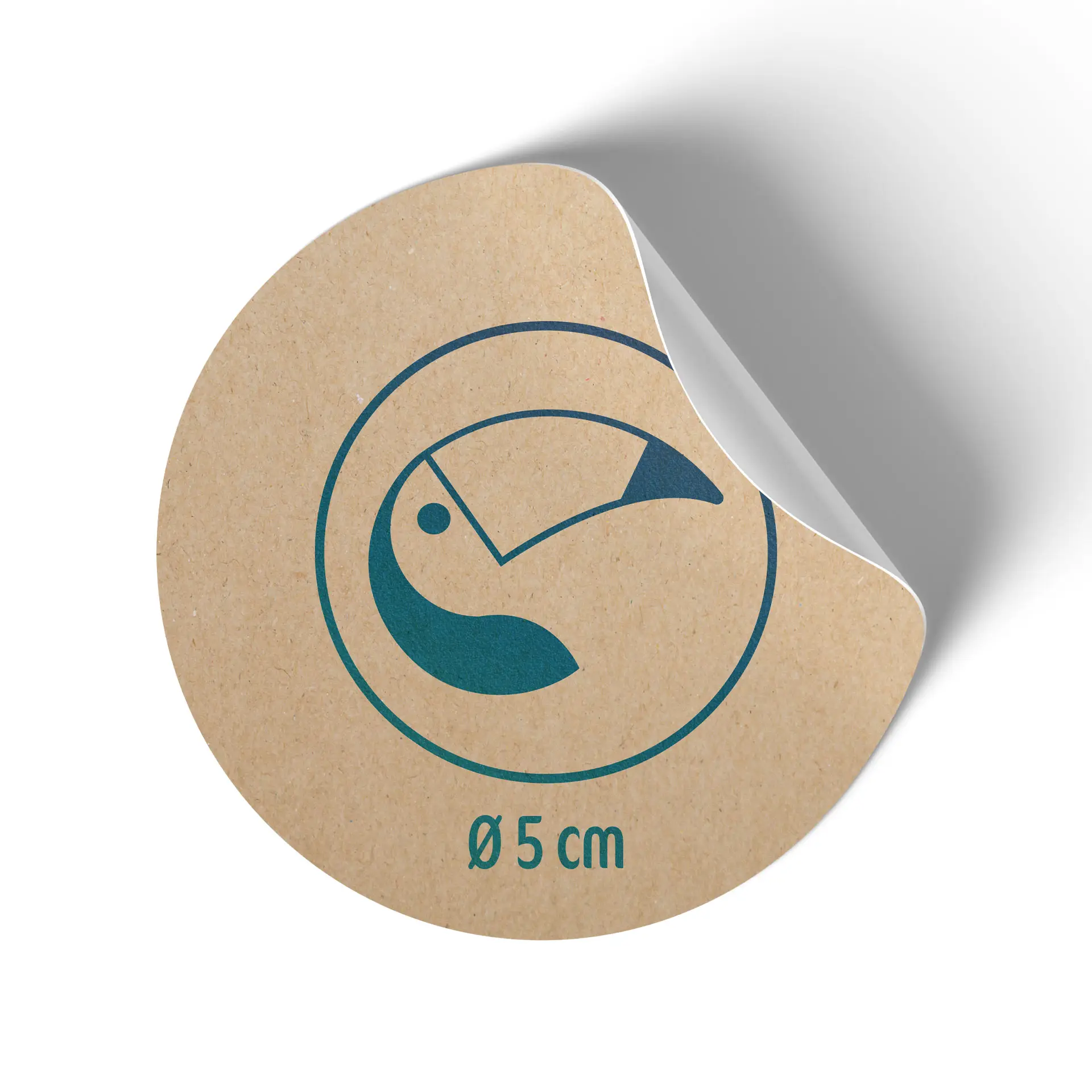 Rond kraftpapierlabel, 5 cm in diameter, met een blauw toekan ontwerp en een iets losgetrokken achterkant.