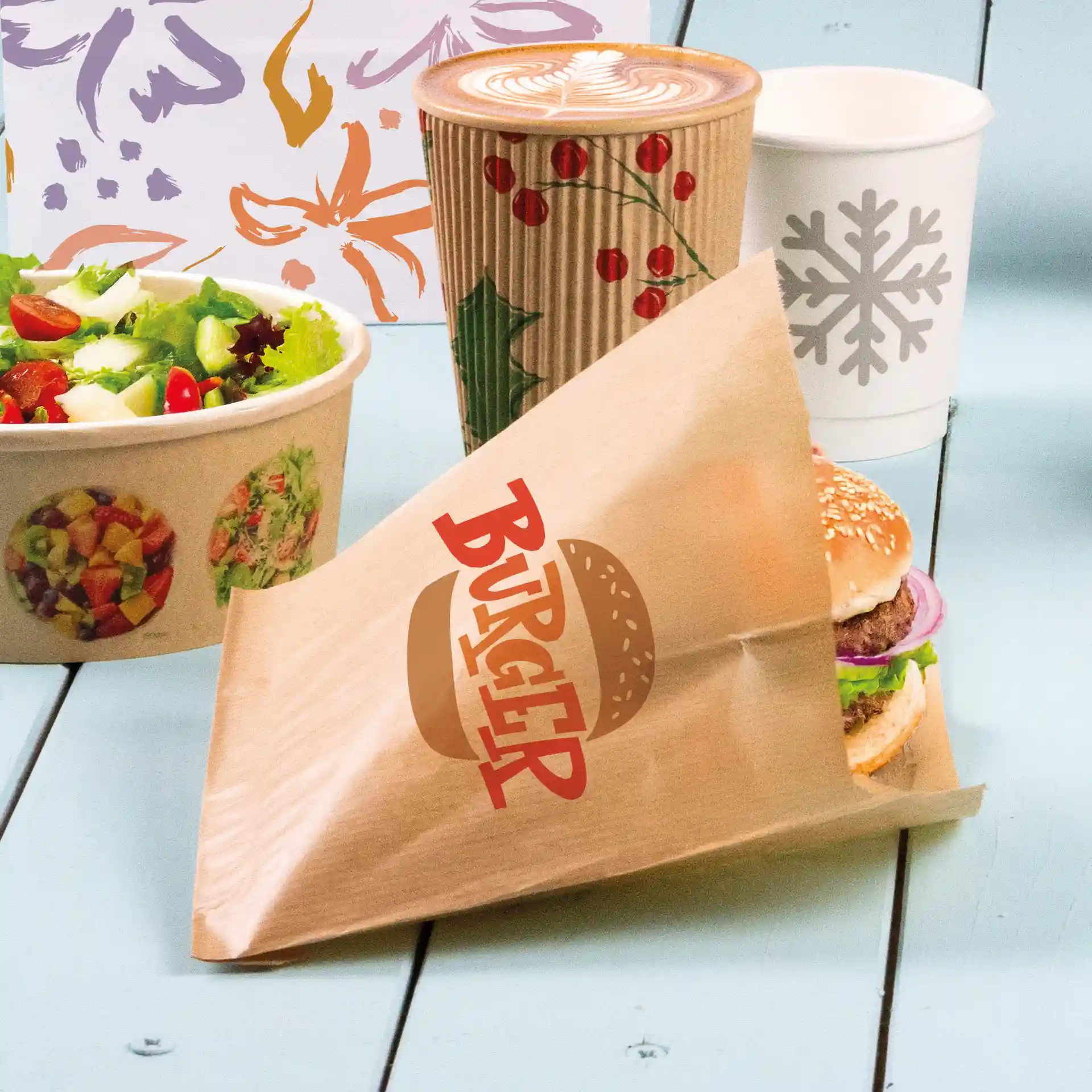 Bruine bedrukte burgerhuls met een zichtbare burger, saladekom en koffiekop op de achtergrond.