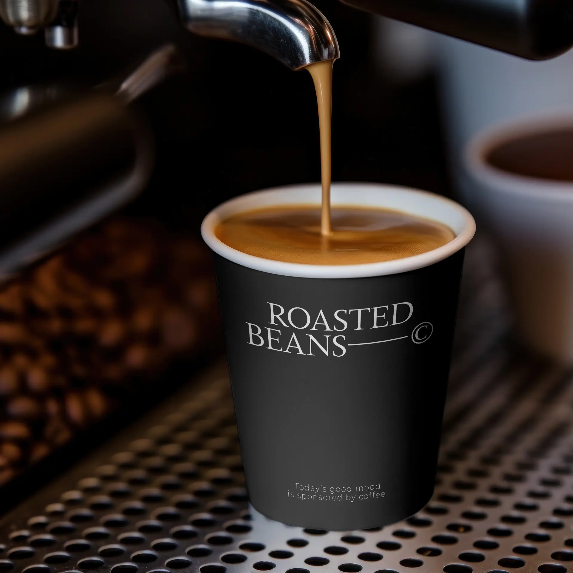 Zwarte beker met logo, gevuld met koffie, op een metalen oppervlak met koffiebonen op de achtergrond.