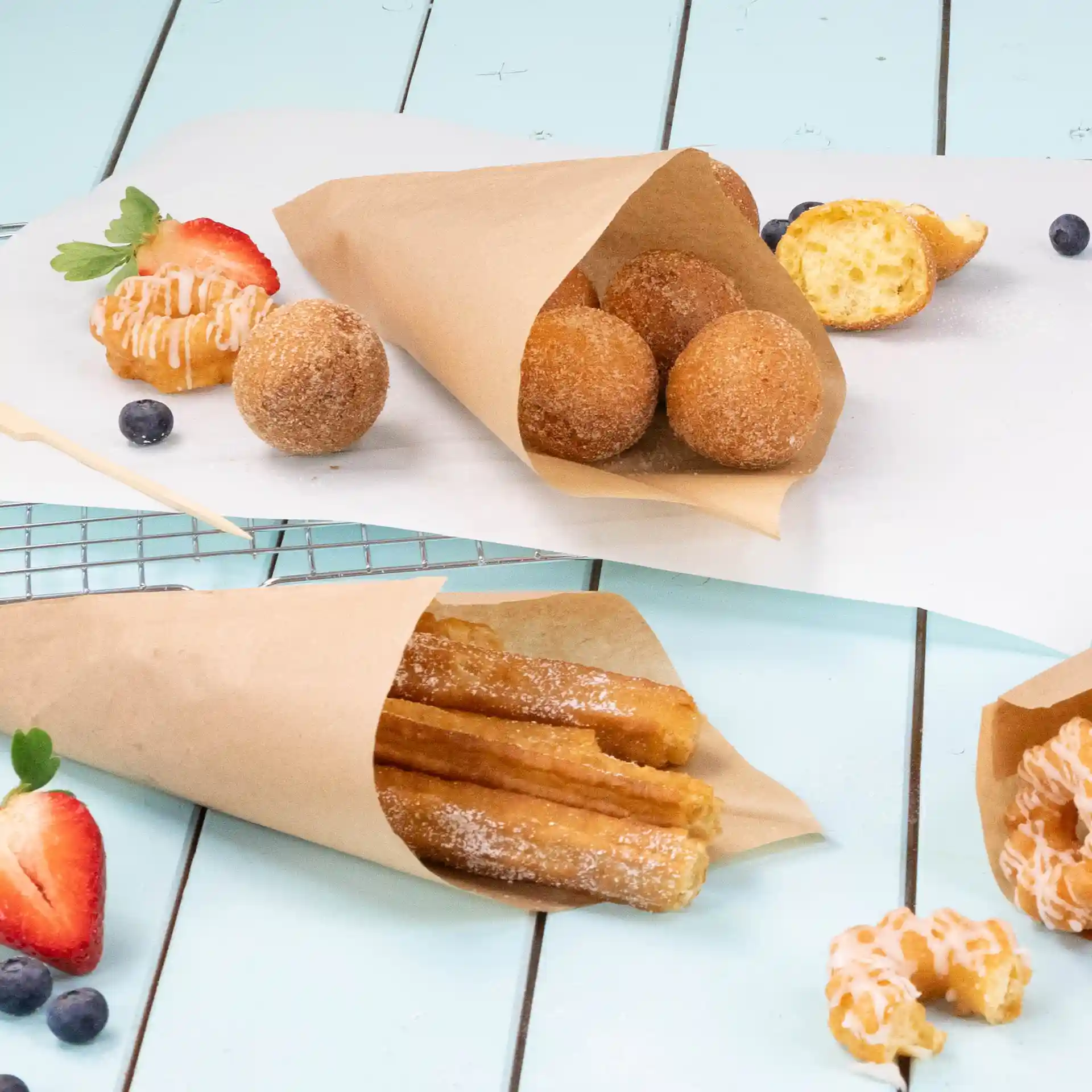 Afbeelding van bruine papieren zakken met gefrituurde snacks, waaronder churros en donutgaten, op een lichtblauwe ondergrond.