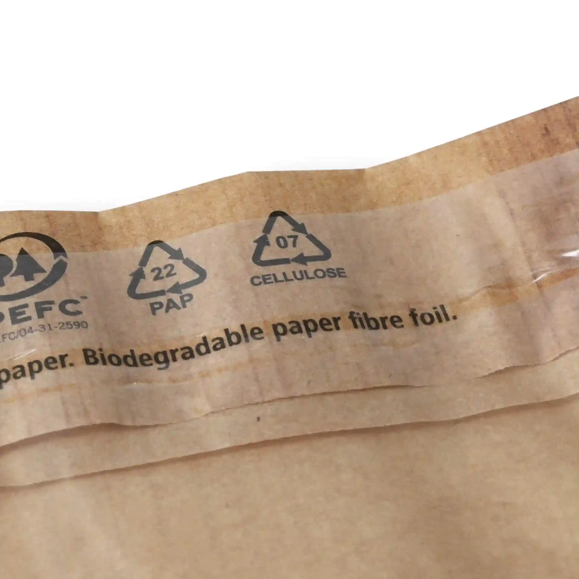 Bruine snackzak met venster en kleefsluiting, toont recycling symbolen en bedrukte tekst aan de bovenrand.