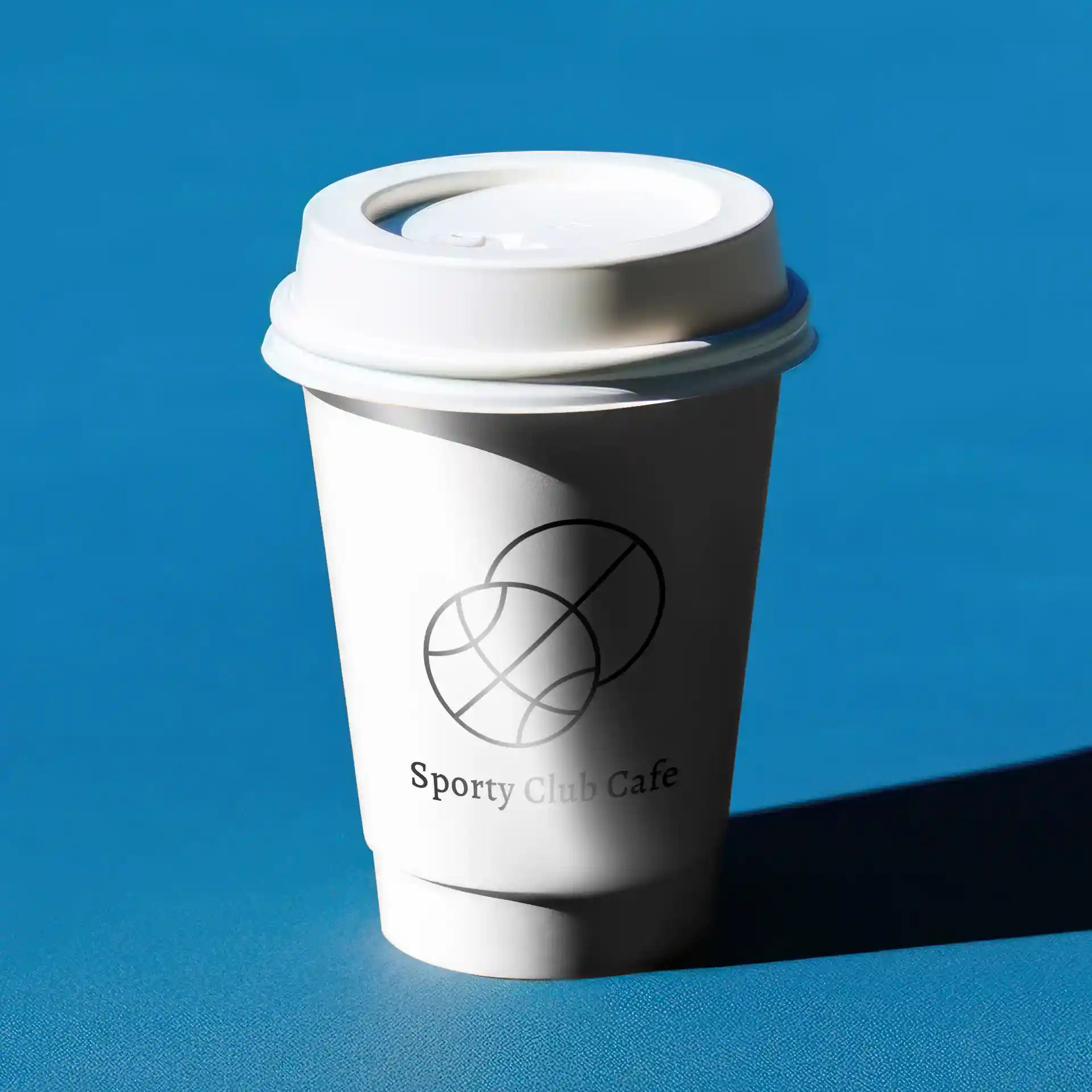 Witte dubbelwandige papieren beker met deksel, met een logo en tekst, geplaatst op een blauwe achtergrond.