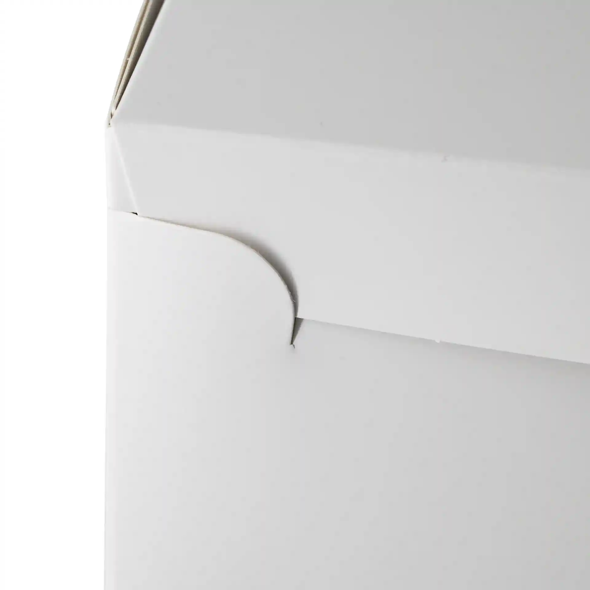 Close-up van een witte taartdoos met een gebogen flap aan de zijkant.