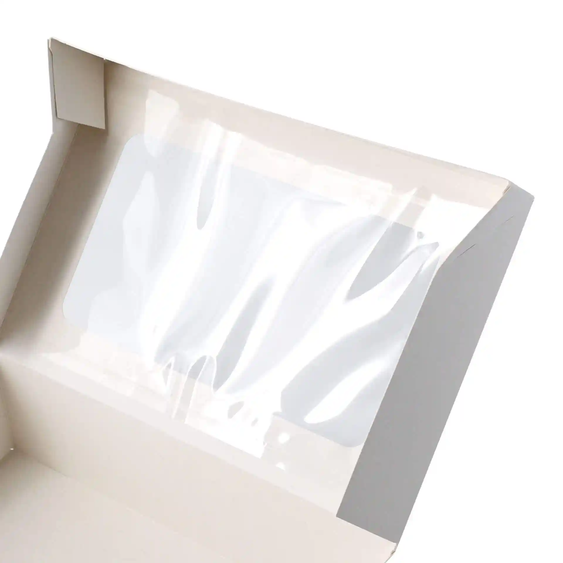 Interieur van een witte kartonnen cupcake-doos met een helder cellulosevenster.