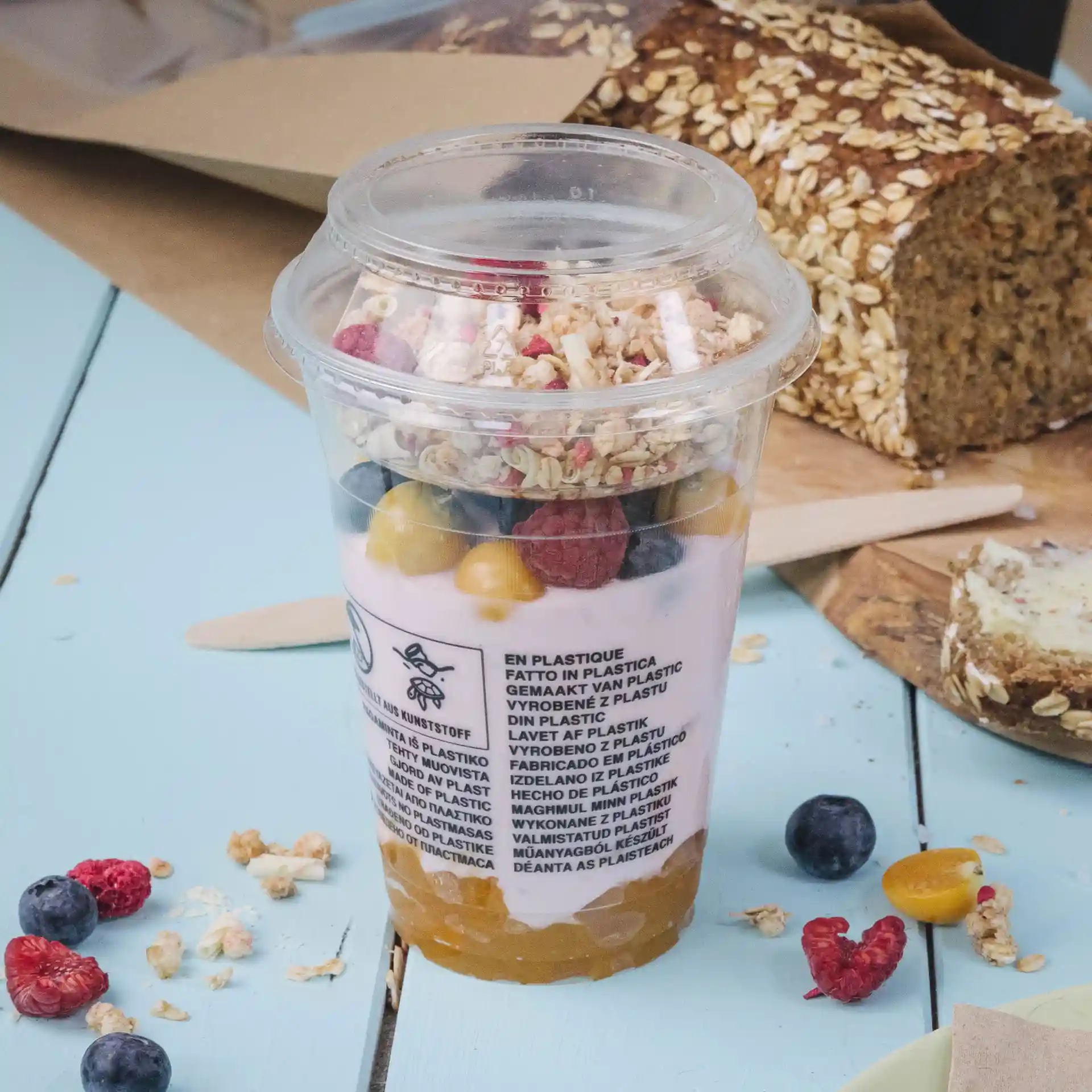 Heldere plastic beker gevuld met yoghurt, granola en gemengd fruit, met een diameter van 95 mm.