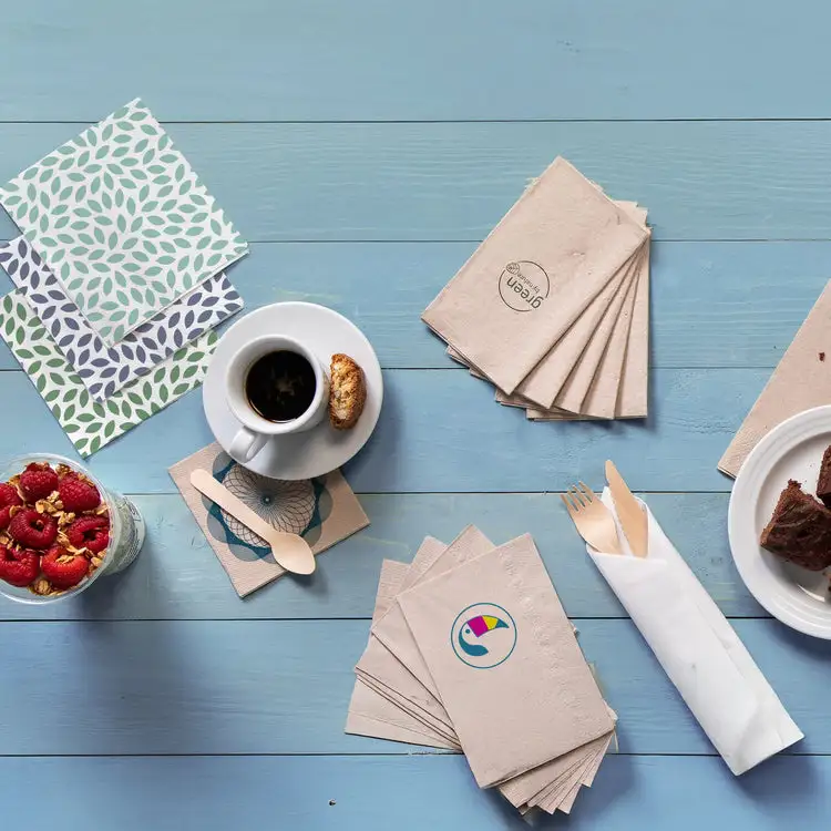 Tafelaankleding met patroonservetten, drinkbeker met koekje, dessert en verse frambozen in een glas.