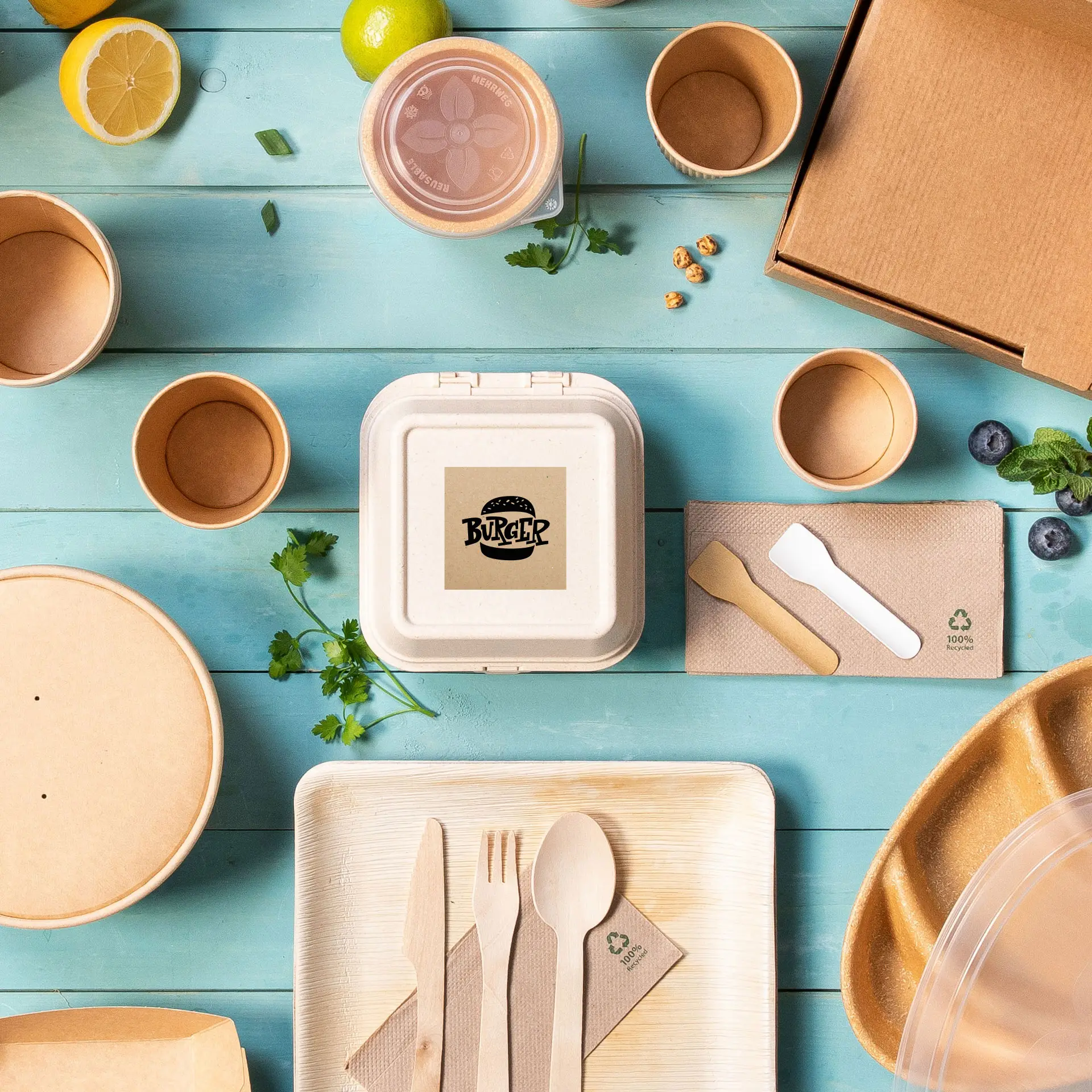 Een vierkante kraftpapiercontainer met een burgerlogo, omgeven door verschillende wegwerpvoedselverpakkingen en bestek.