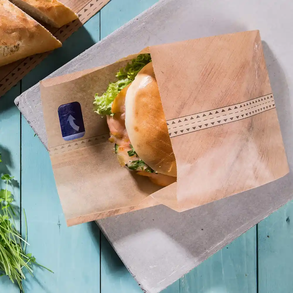 Wrap met een sandwich met sla en andere vullingen op een blauwe houten ondergrond.
