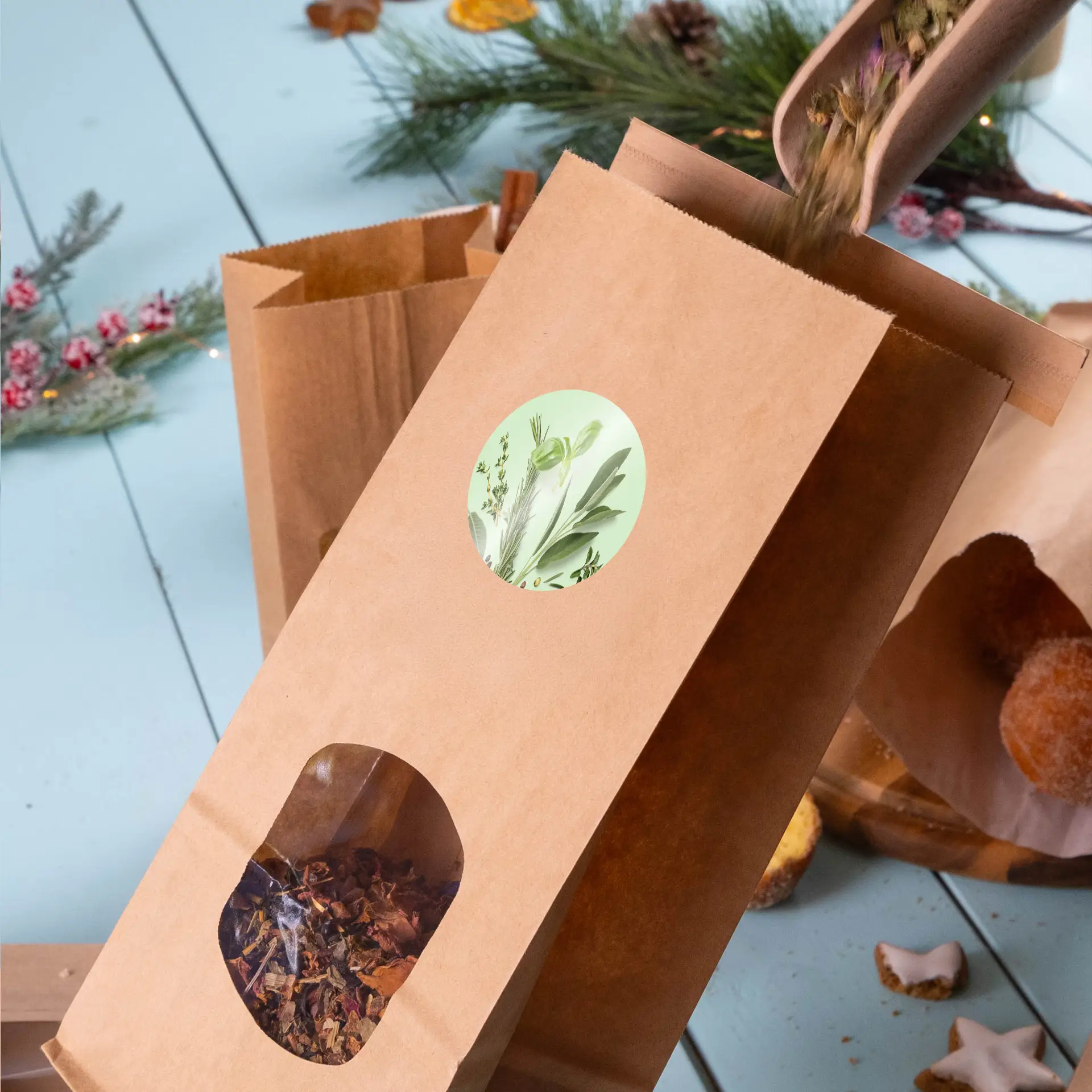 Een bruin kraftpapier zak met een ronde groene label en een transparant venster, gevuld met losse kruiden thee ingrediënten.