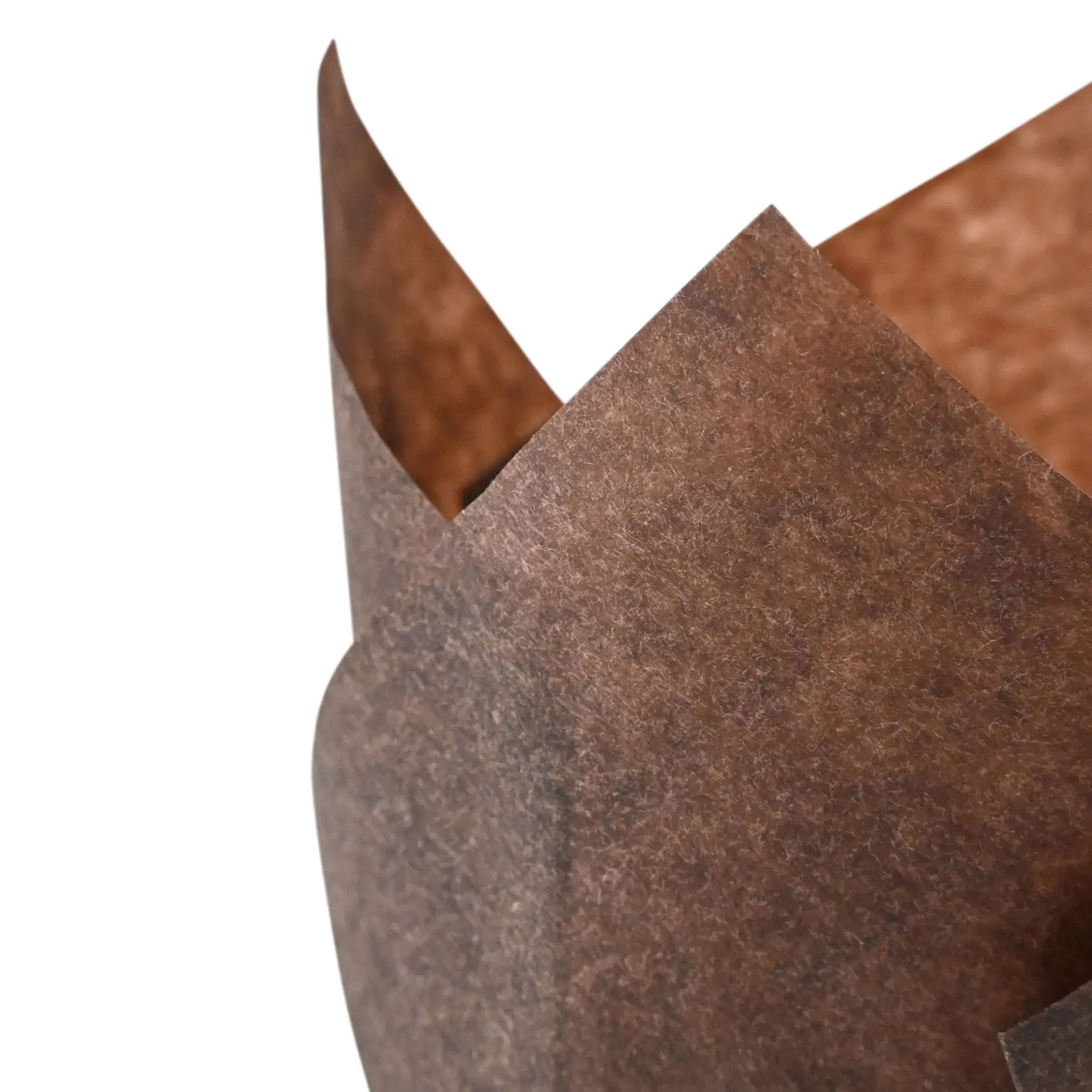 Een bruine vetvrije papieren muffinbekertje met een gerimpelde rand, geschikt voor het bakken van cupcakes.