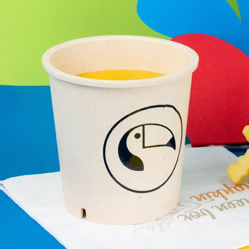 Donkergroene herbruikbare beker gevuld met een groentegerecht, met een aanpasbaar ontwerpgebied gemarkeerd "Jouw ontwerp."