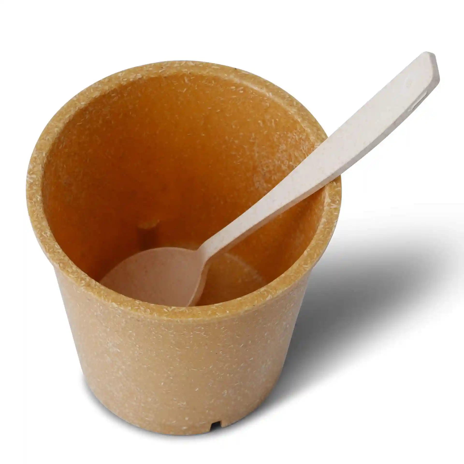 Ronde bruine herbruikbare beker van bio-compound, 400 ml capaciteit, met een witte lepel erin.