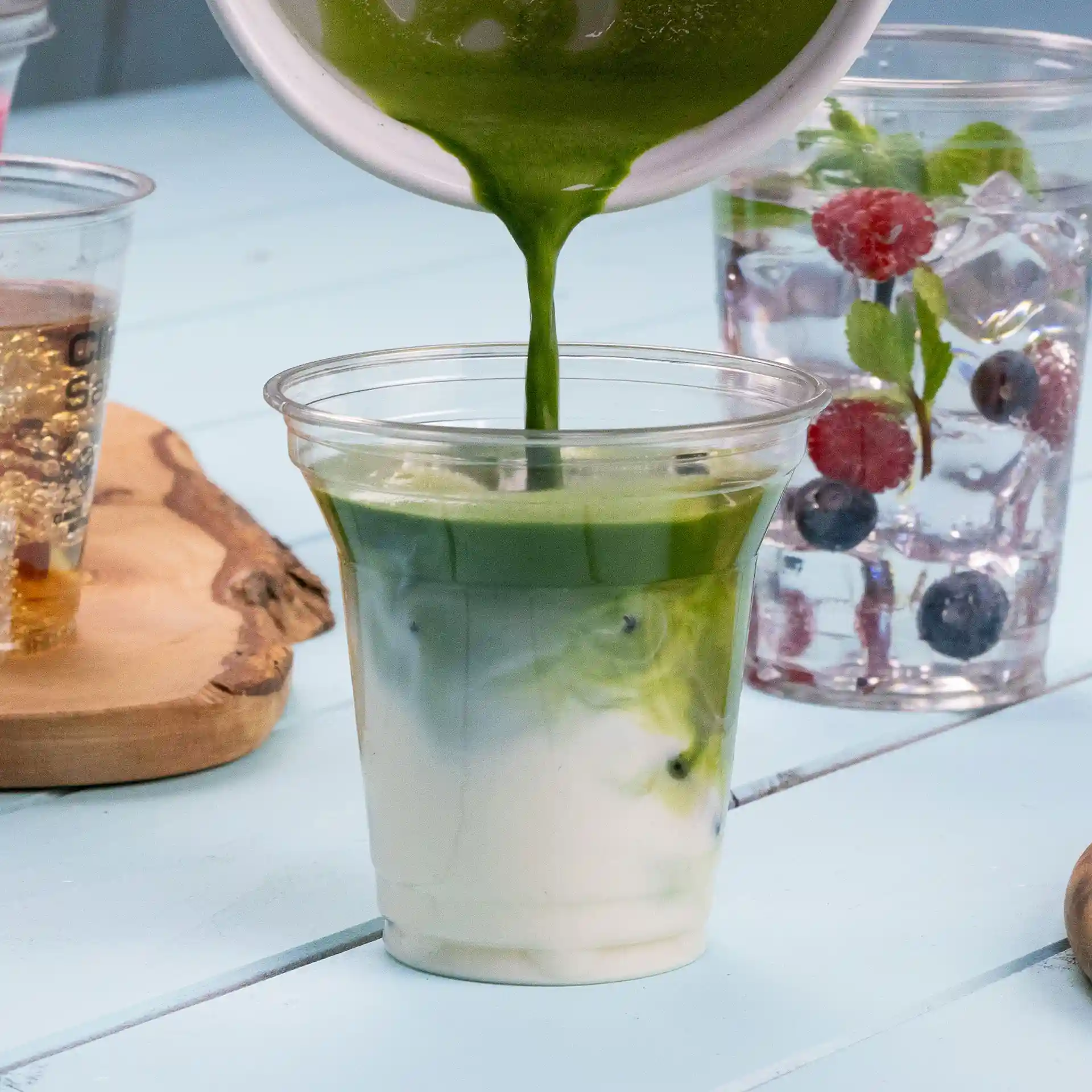 Transparante 8 oz rPET beker wordt gevuld met een groene drank, toont gelaagde kleuren van groen en wit.