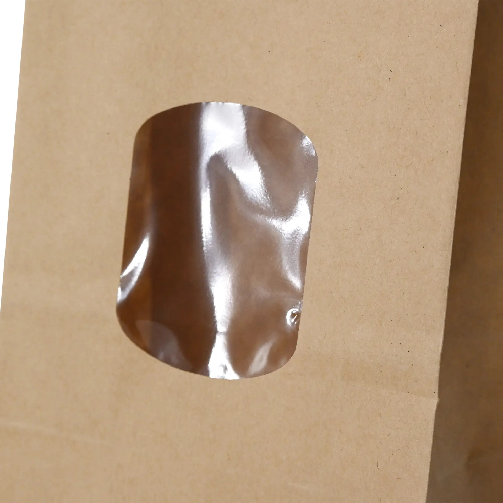 Bruine kraftpapieren tas met een transparant PP-venster, met een tin tie sluiting, 8,5 x 5 x 24 cm groot.
