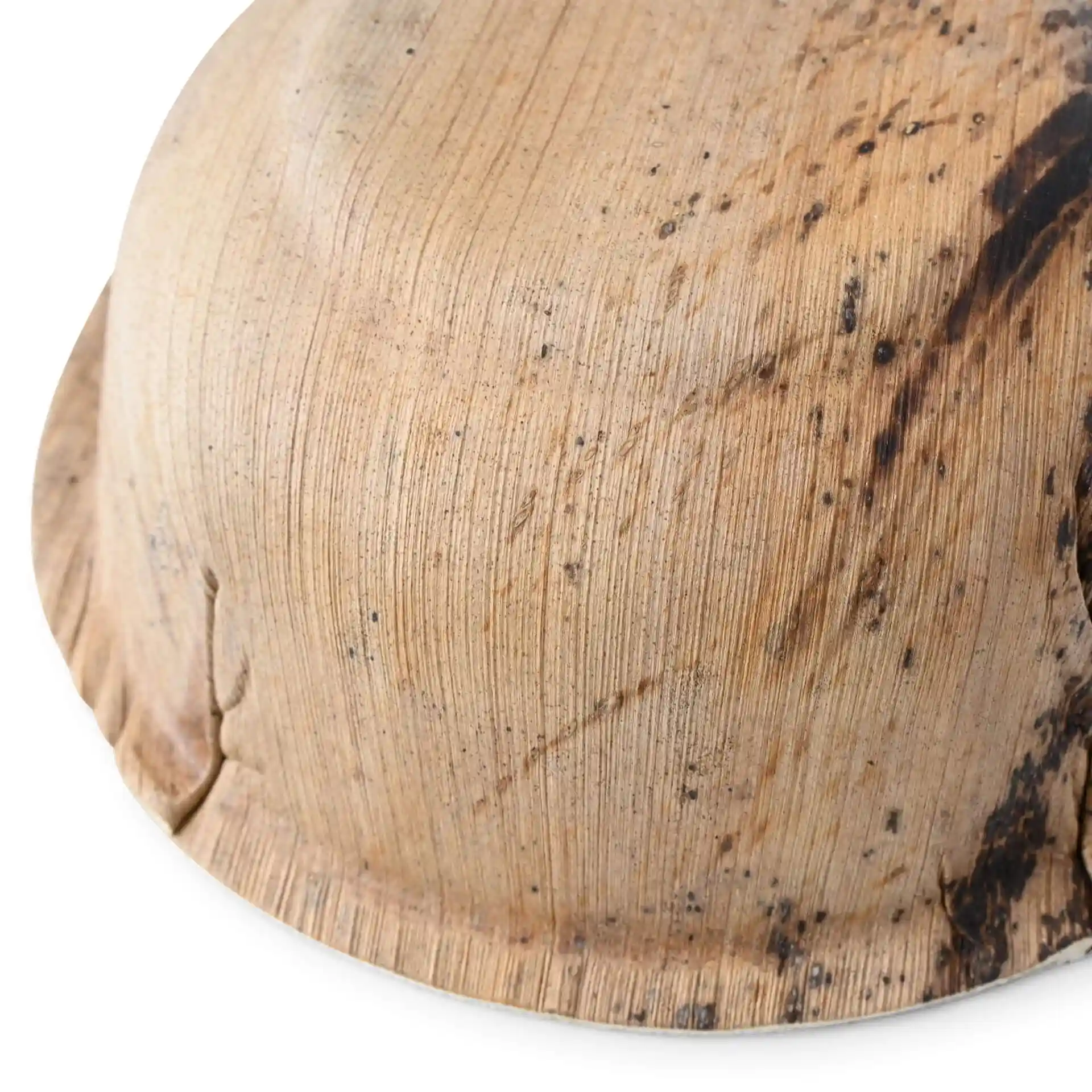 Close-up van een ronde palmbladkom met een gestructureerd oppervlak en een lichte donkere vlek.