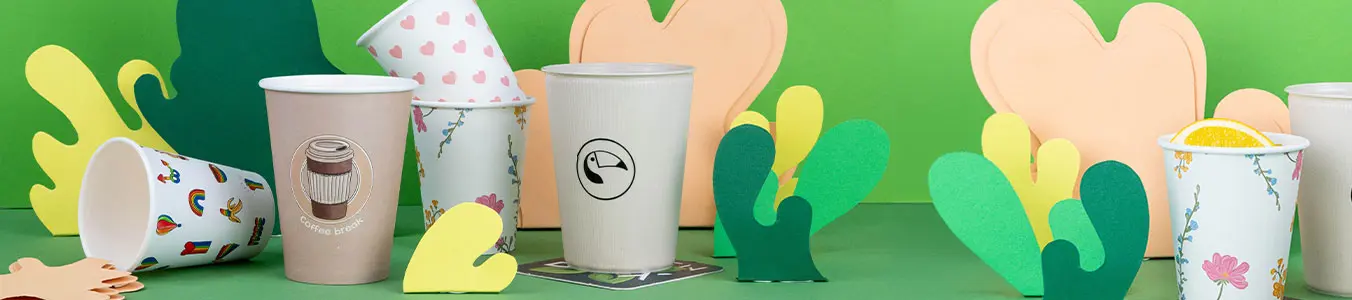 Afbeelding van verschillende aanpasbare geprinte bekers met kleurrijke papercut-outs op een groene achtergrond.
