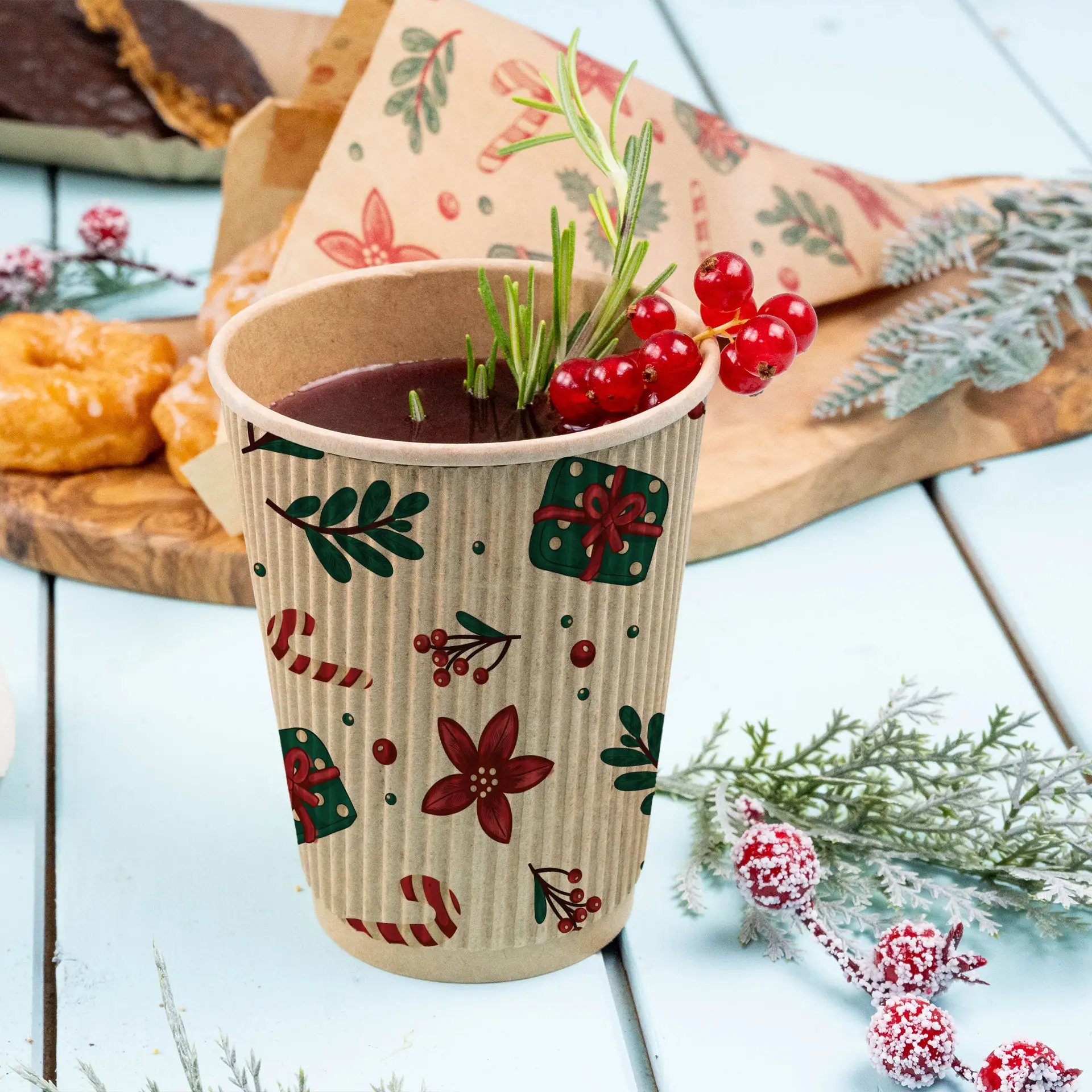 Bruine ribbelbeker met winterontwerp, gevuld met een drankje en gegarneerd met rode bessen en rozemarijn, op een lichtblauwe ondergrond.