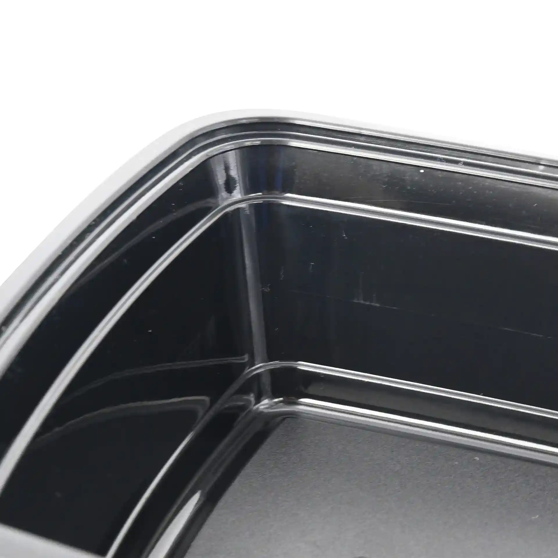 Close-up van een zwarte rechthoekige herbruikbare container met zichtbare binnenhoeken en randen.