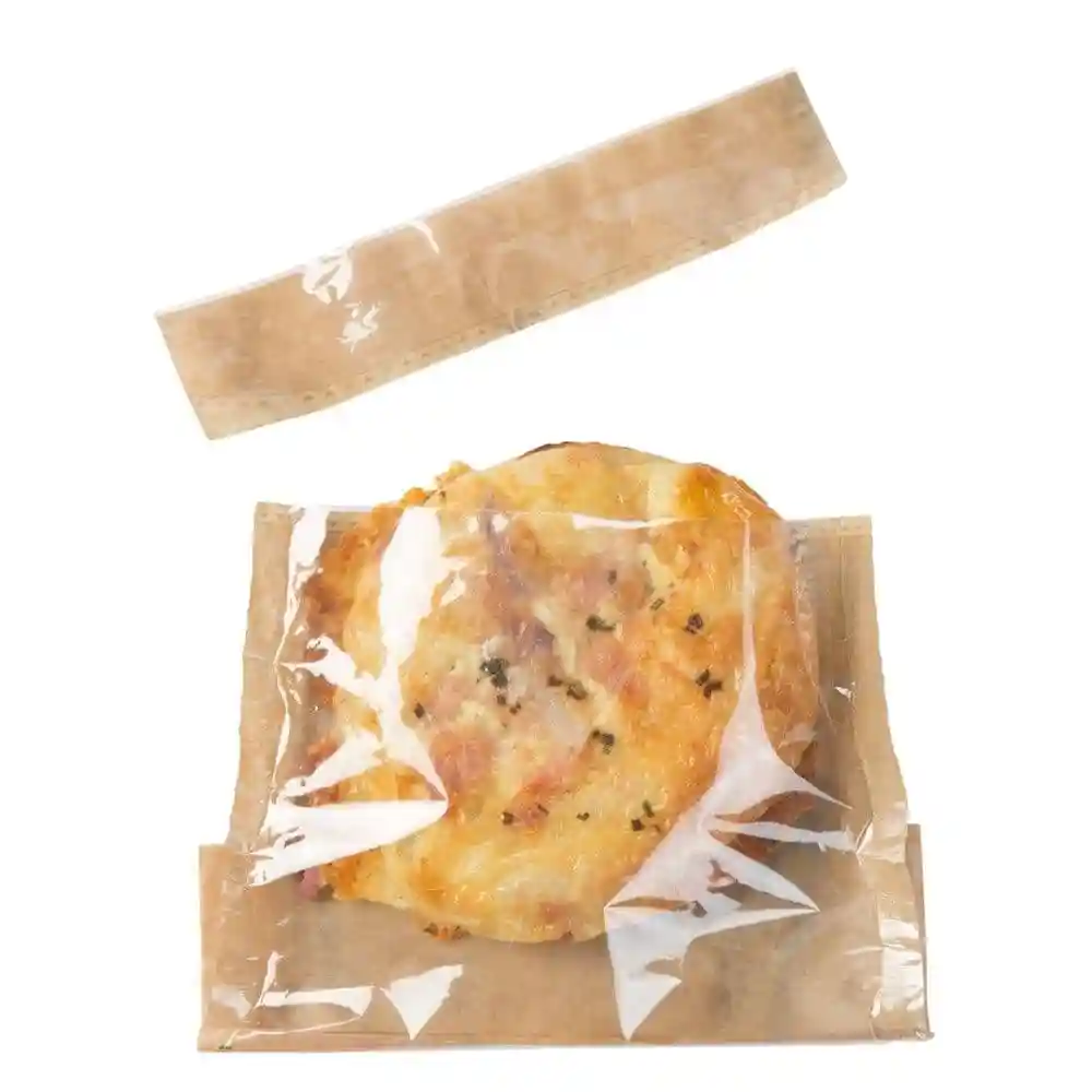 Snackzak van papier met palmbladprint, bevat een gebakken item verpakt in doorzichtig folie.