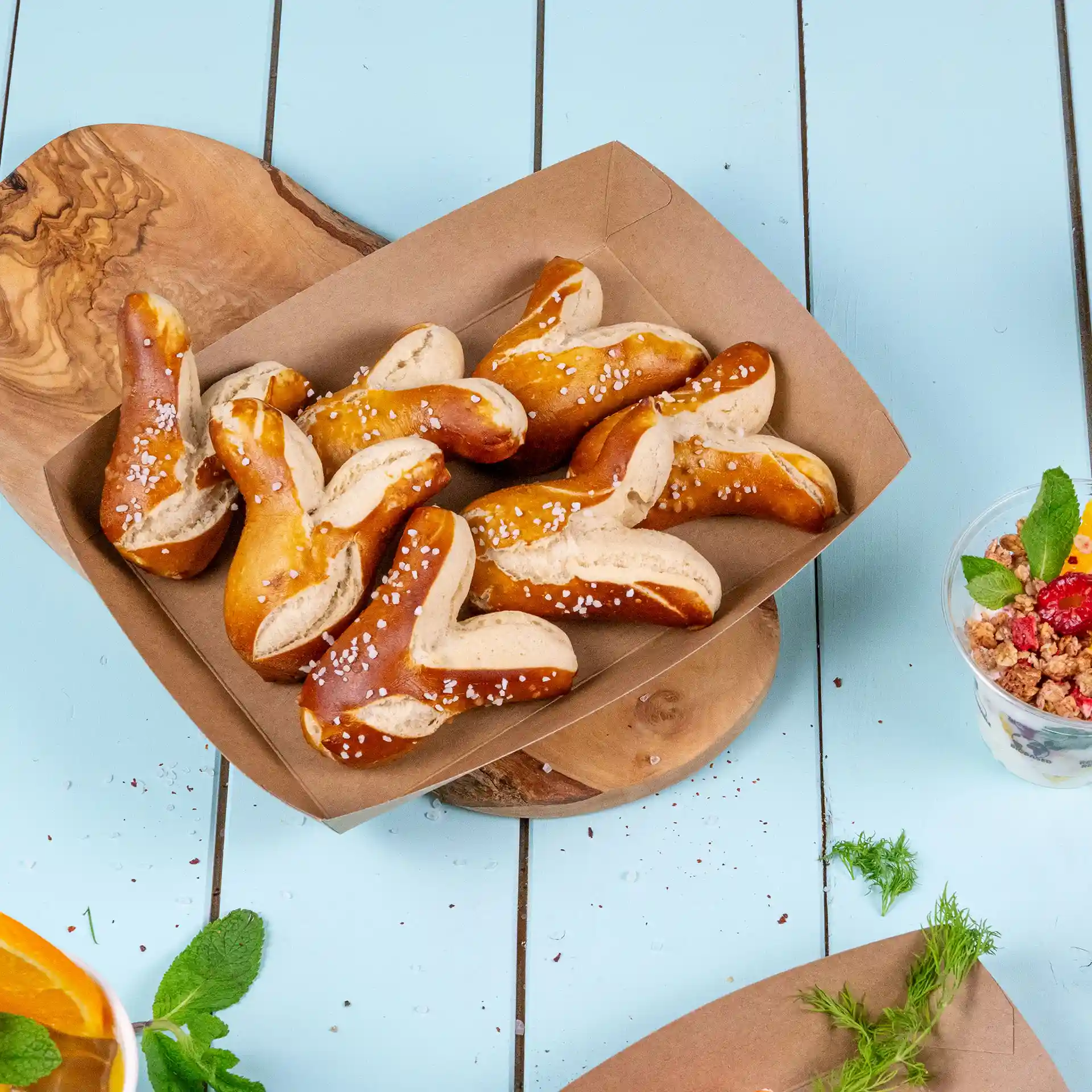Een bruine kartonnen voedseltray gevuld met verschillende pretzelstukjes, bestrooid met grof zout.