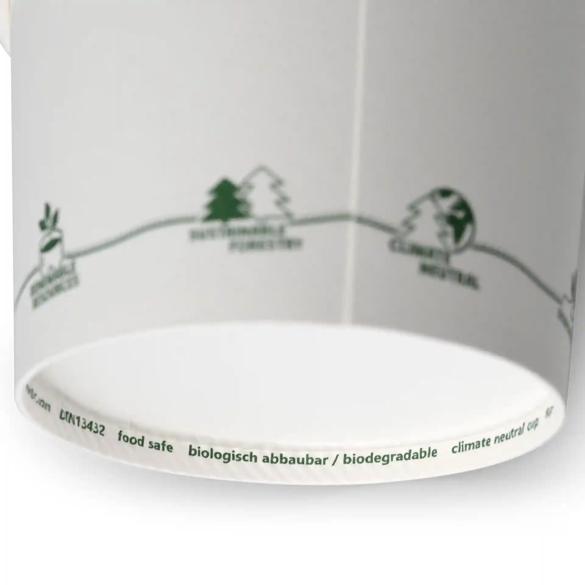 Ronde kartonnen soepkom met geprinte eco-iconen en een witte binnenkant, met verschillende groene symbolen langs de rand.