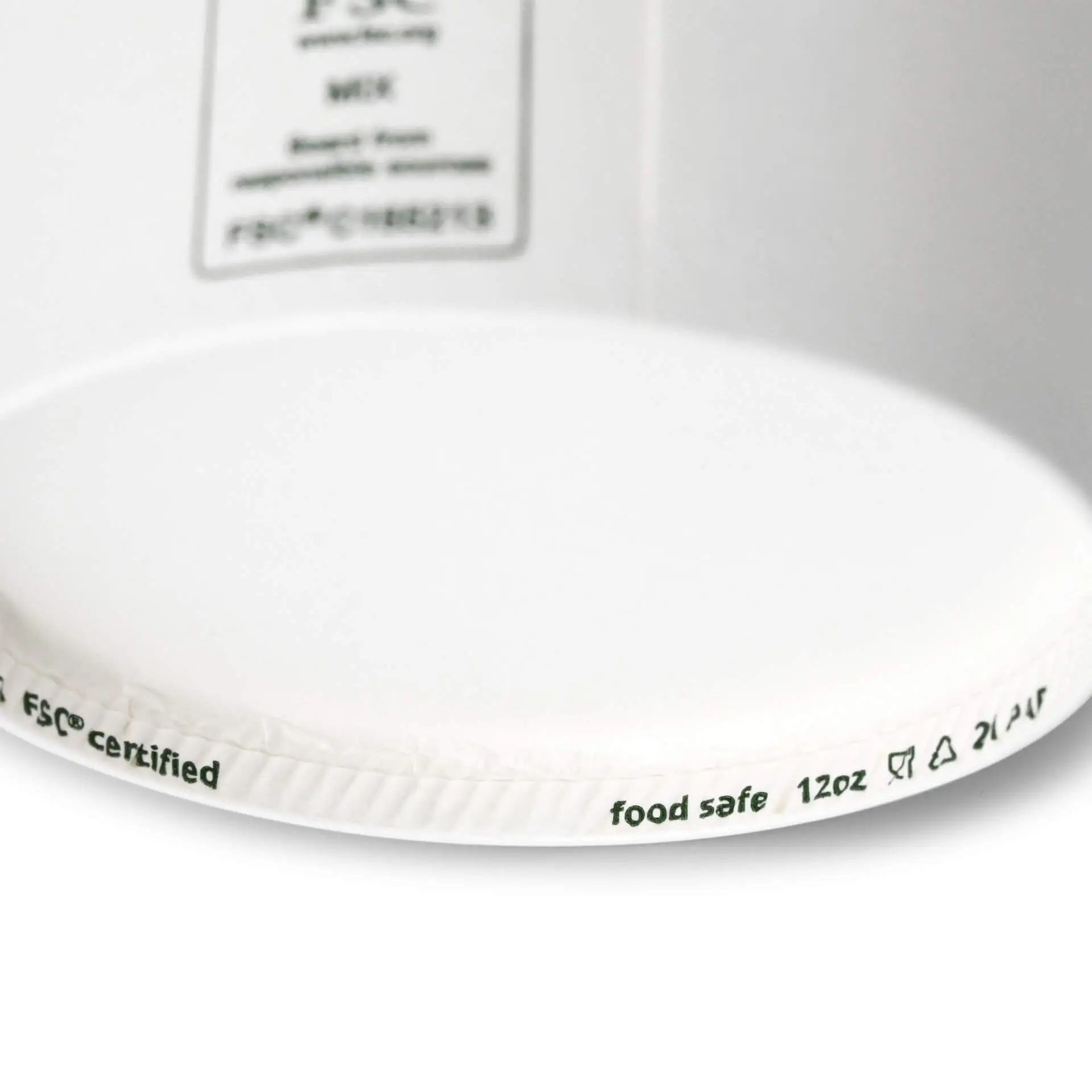 Een witte papieren ijsbekerglas met markeringen voor 12 oz capaciteit en een "thuiscomposteerbaar" label op de rand.