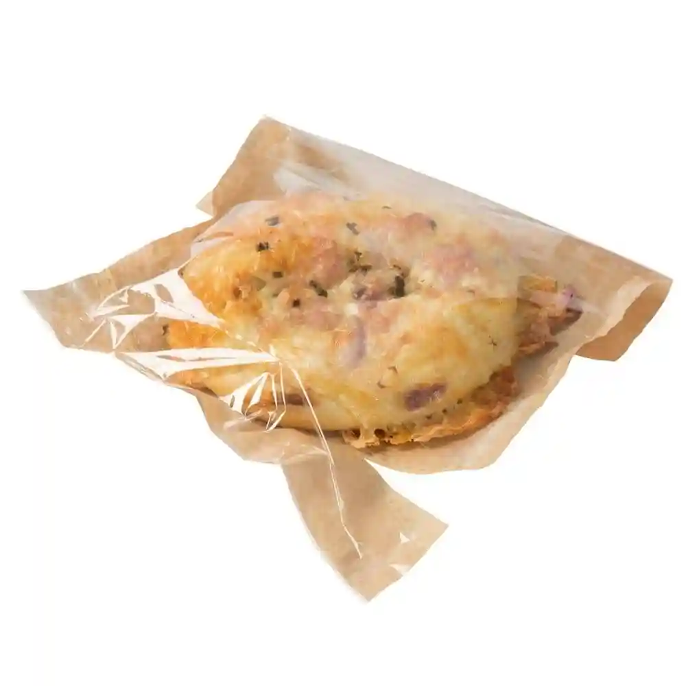 Snackzak van bedrukt papier met een palmbladontwerp, bevat een voedselitem verpakt in doorzichtig folie.