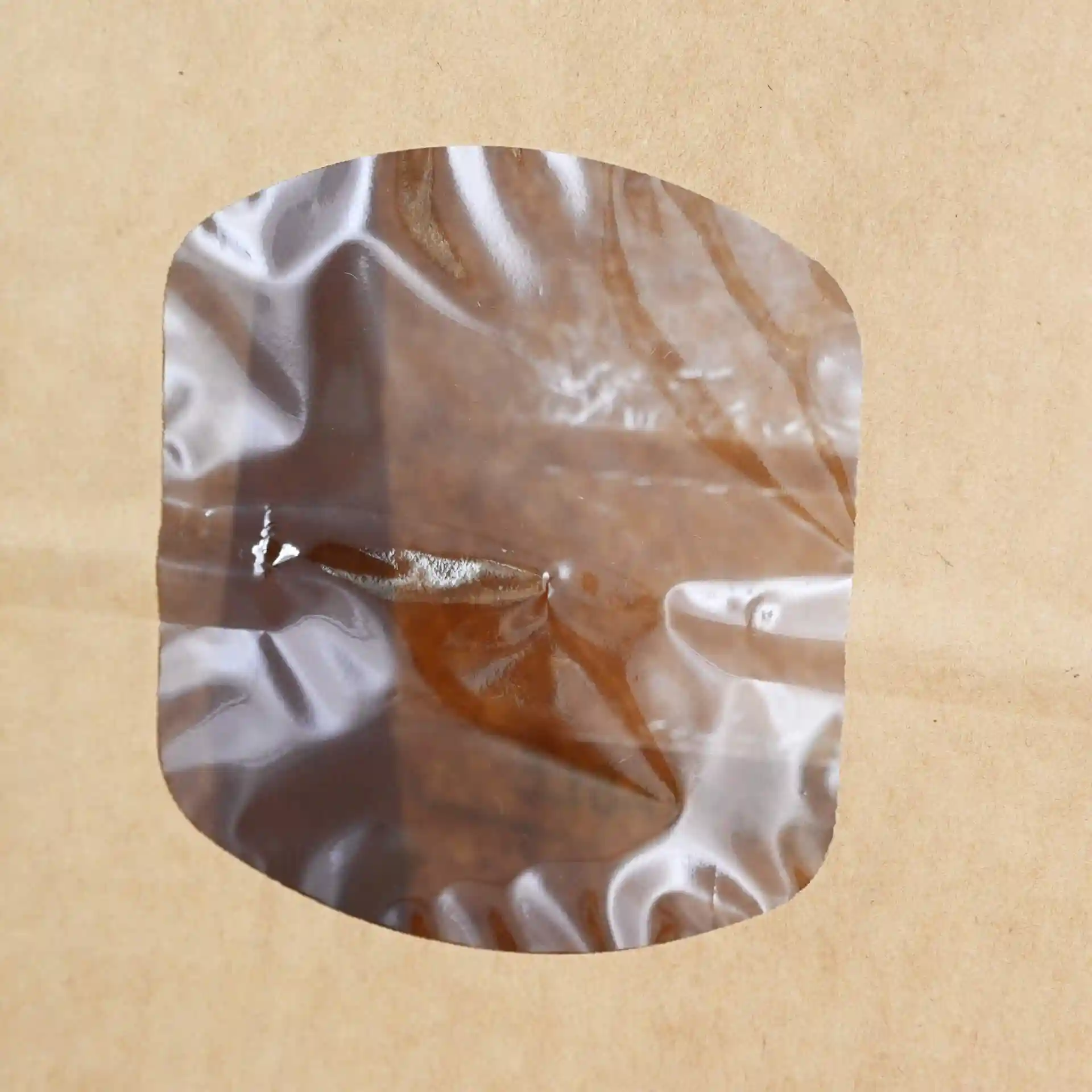 Transparant venster op een bruine kraftpapieren tas, dat de inhoud toont.