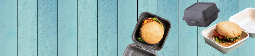 Groene cartoonchef met een lepel, naast een burger in een bruine wegwerpdoos op een blauwe houten achtergrond.