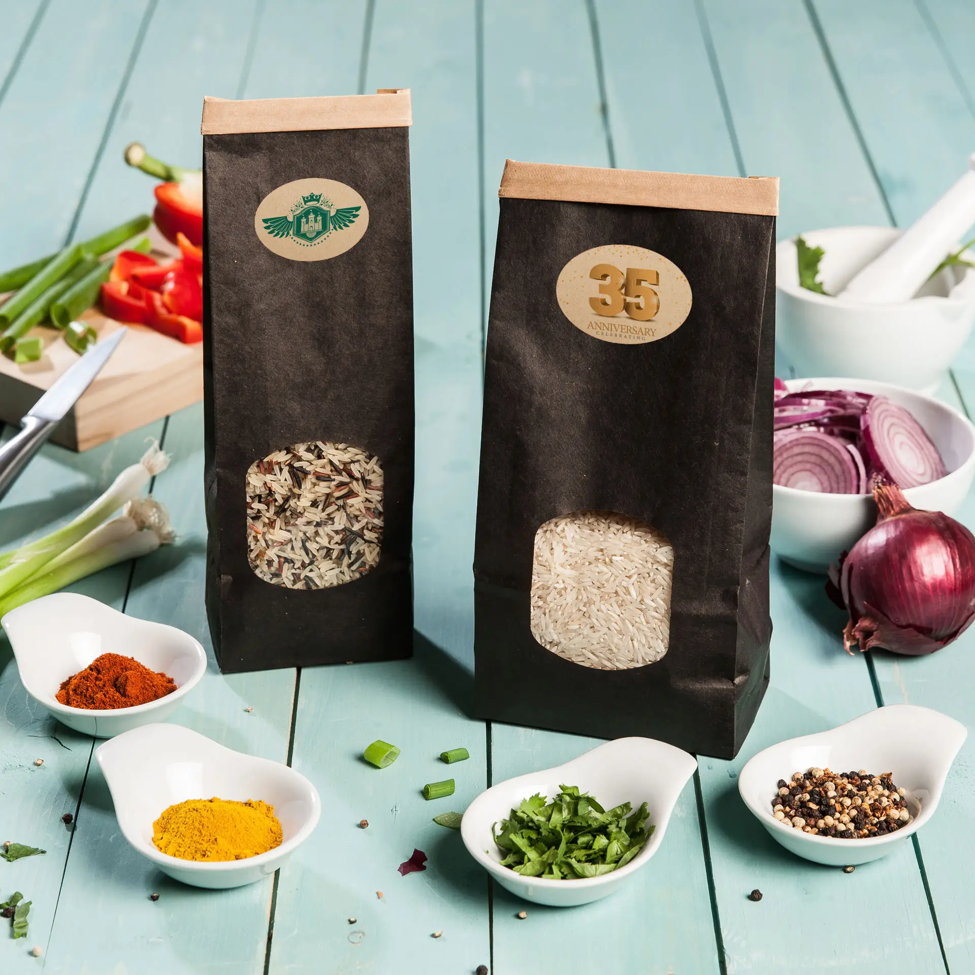 Twee papieren tassen rijst, één met bruine basmatirijst en één met witte rijst, op een blauwe houten ondergrond met verspreide kruiden.