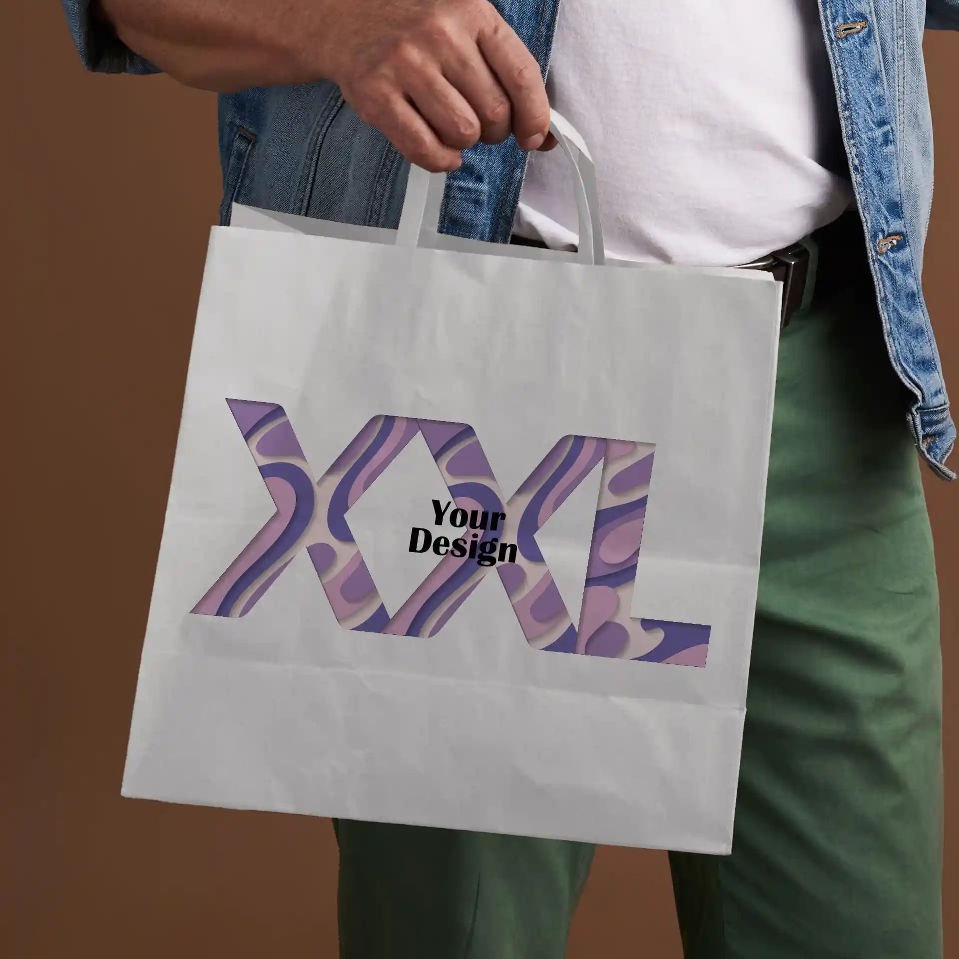 Witte papieren draagtas vastgehouden door een persoon, met een uitsnijdontwerp en de tekst "XXL" en "Jouw Ontwerp".