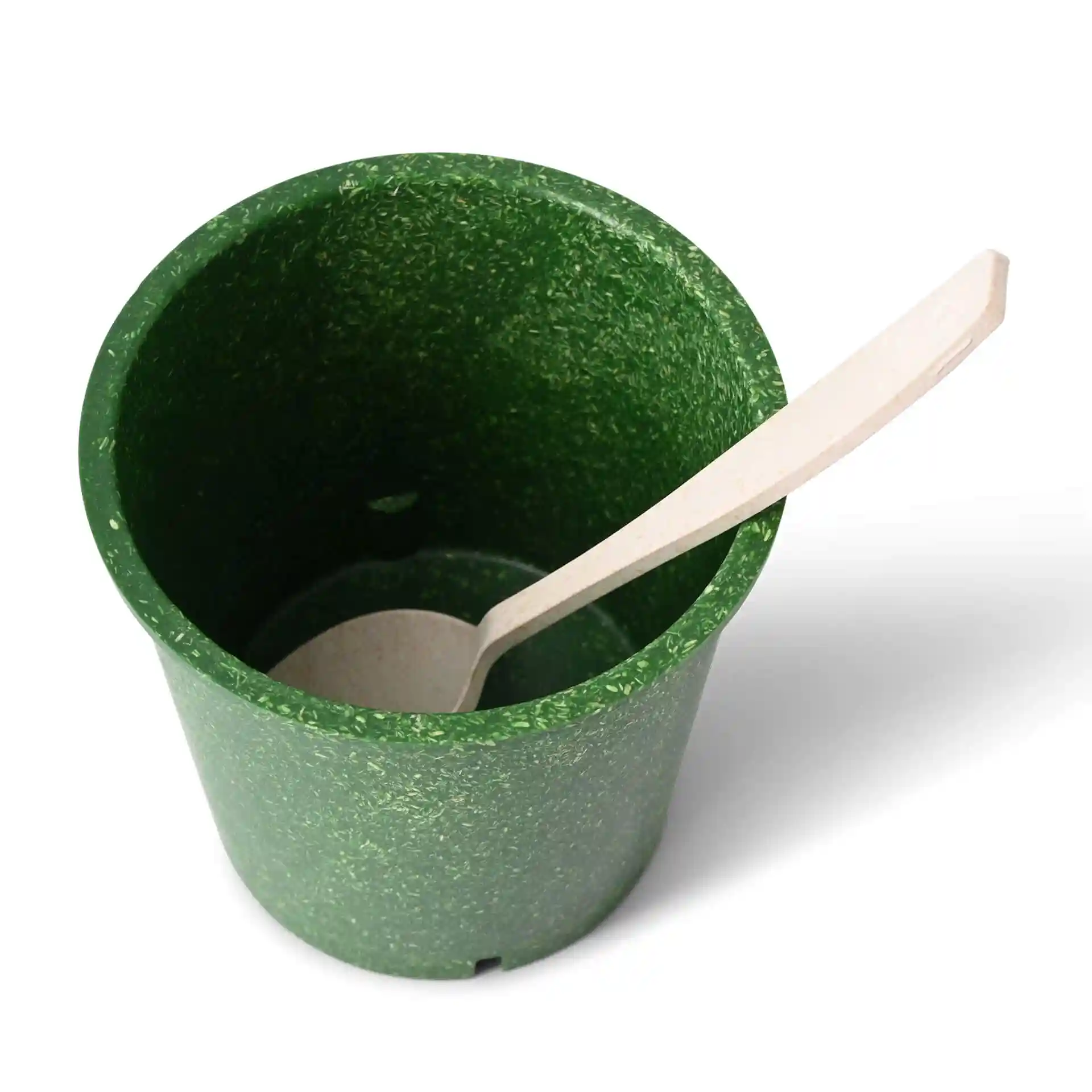 Groene herbruikbare beker van biocomposiet met een ronde vorm en een houten lepel erin.