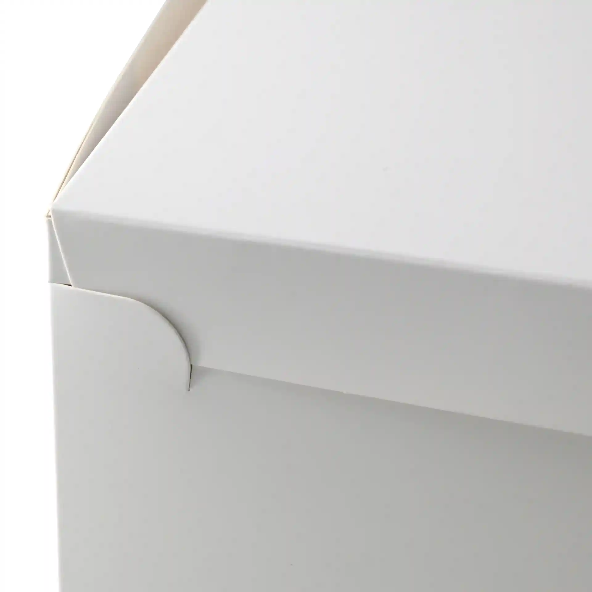 Witte cakebox met deksel, toont de bovenhoek en sluitdetails. Afmetingen zijn 30,5 x 30,5 x 10 cm.
