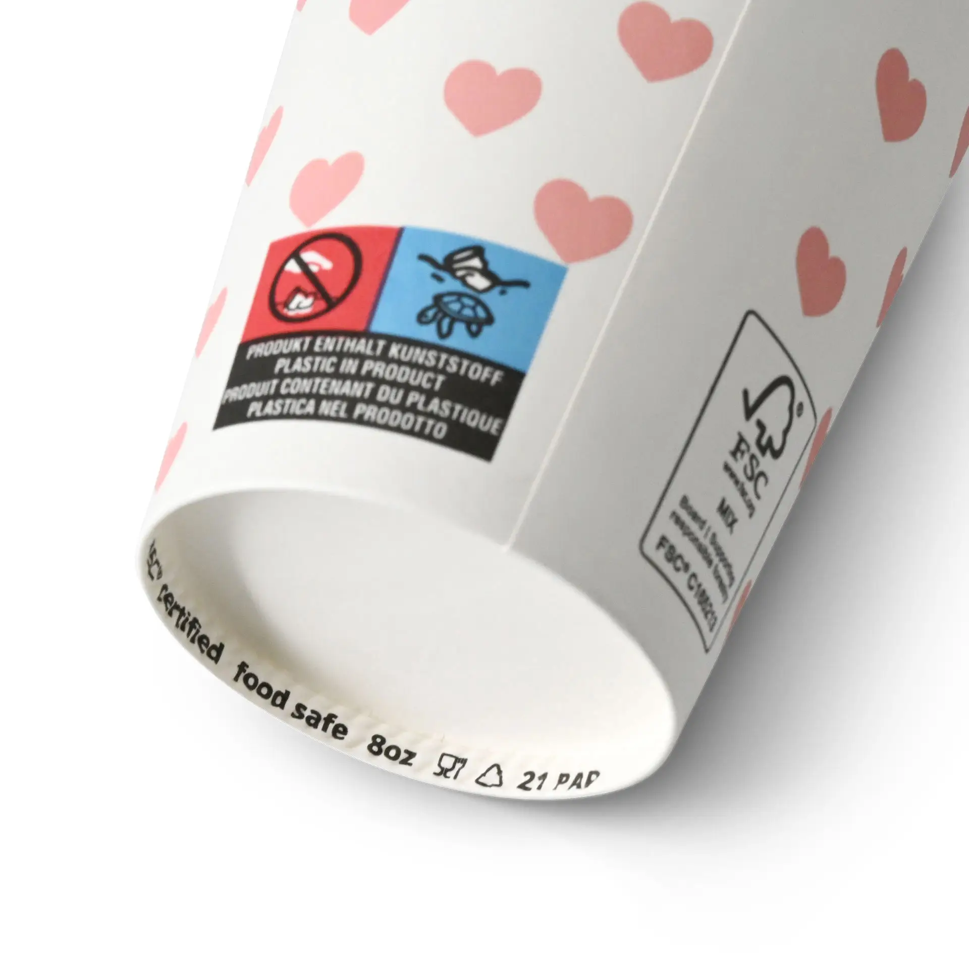 Een witte papieren beker met roze harten, gemarkeerd als voedselveilig en met verschillende etiketten aan de onderkant.
