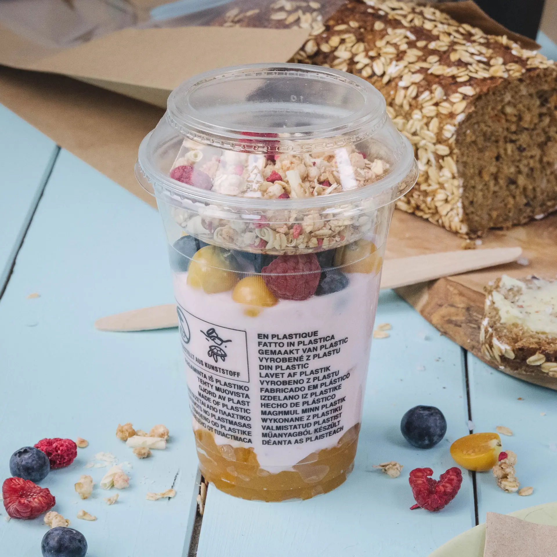 Heldere plastic beker gevuld met yoghurt, granola en fruit, met een diameter van 95 mm en een volume van 130 ml.