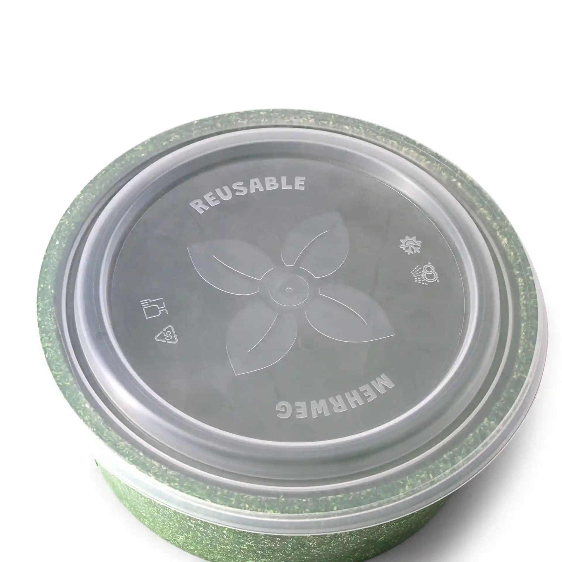 Transparant rond deksel voor een kom met een groene rand, met een bloemmotief en verschillende symbolen bovenop.